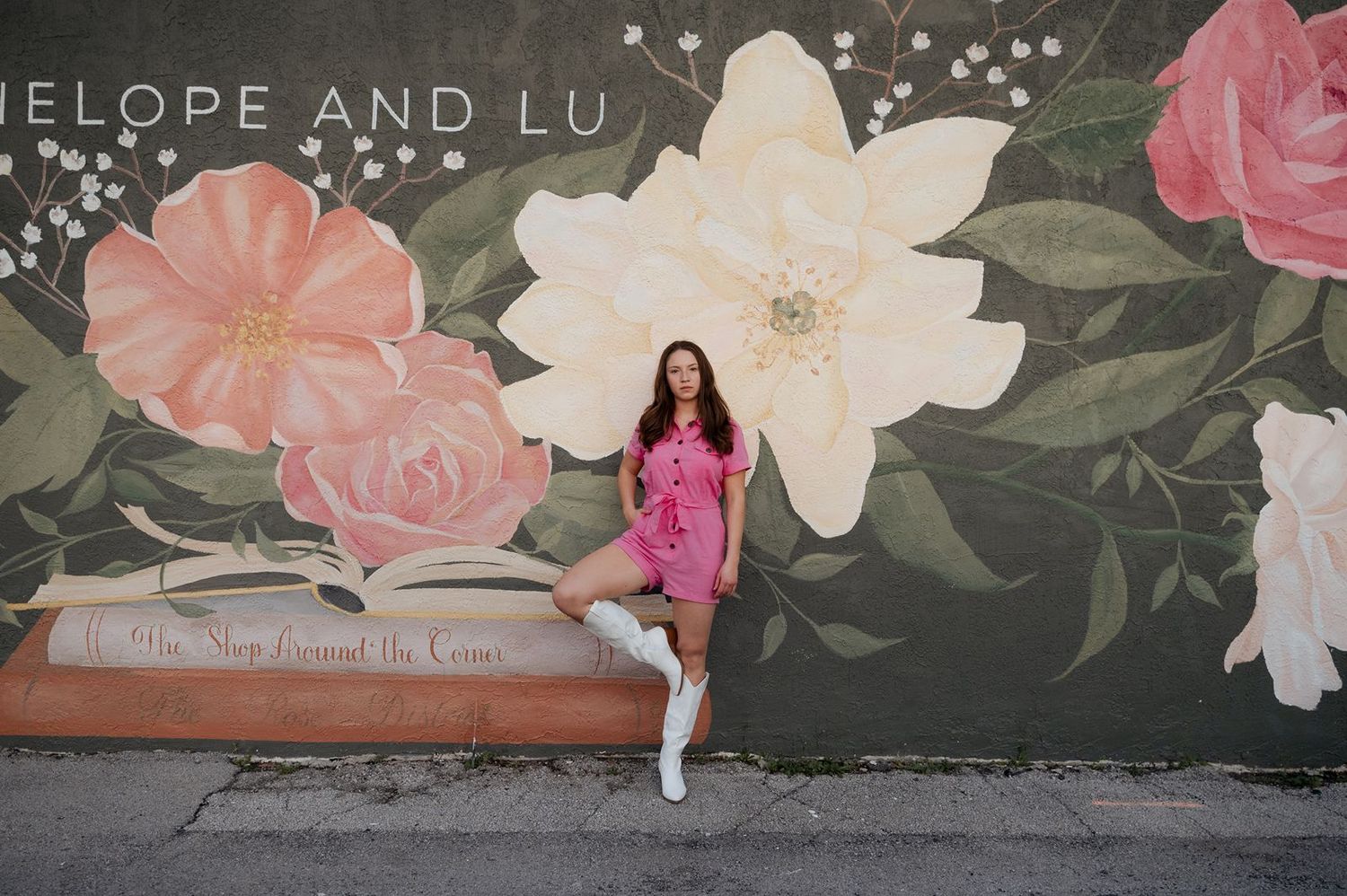 Girl posing on mural in front of Broken Arrow's Book and Bloom by Penelope and Lu