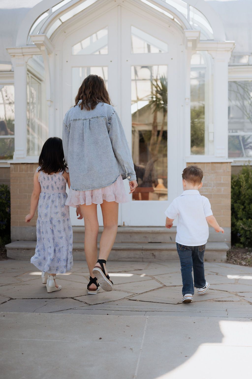 Natural motherhood photography at Woodward Park greenhouse in Tulsa with curious little children