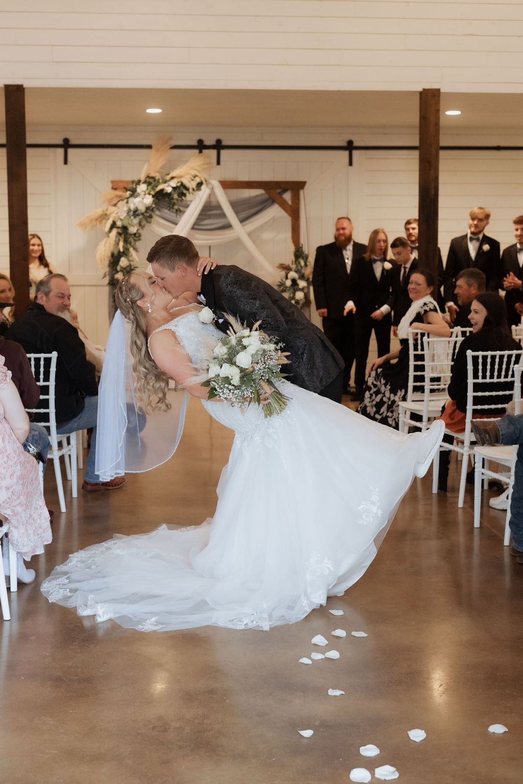 Bride and groom exiting ceremony and stopping for a kiss in the aisle