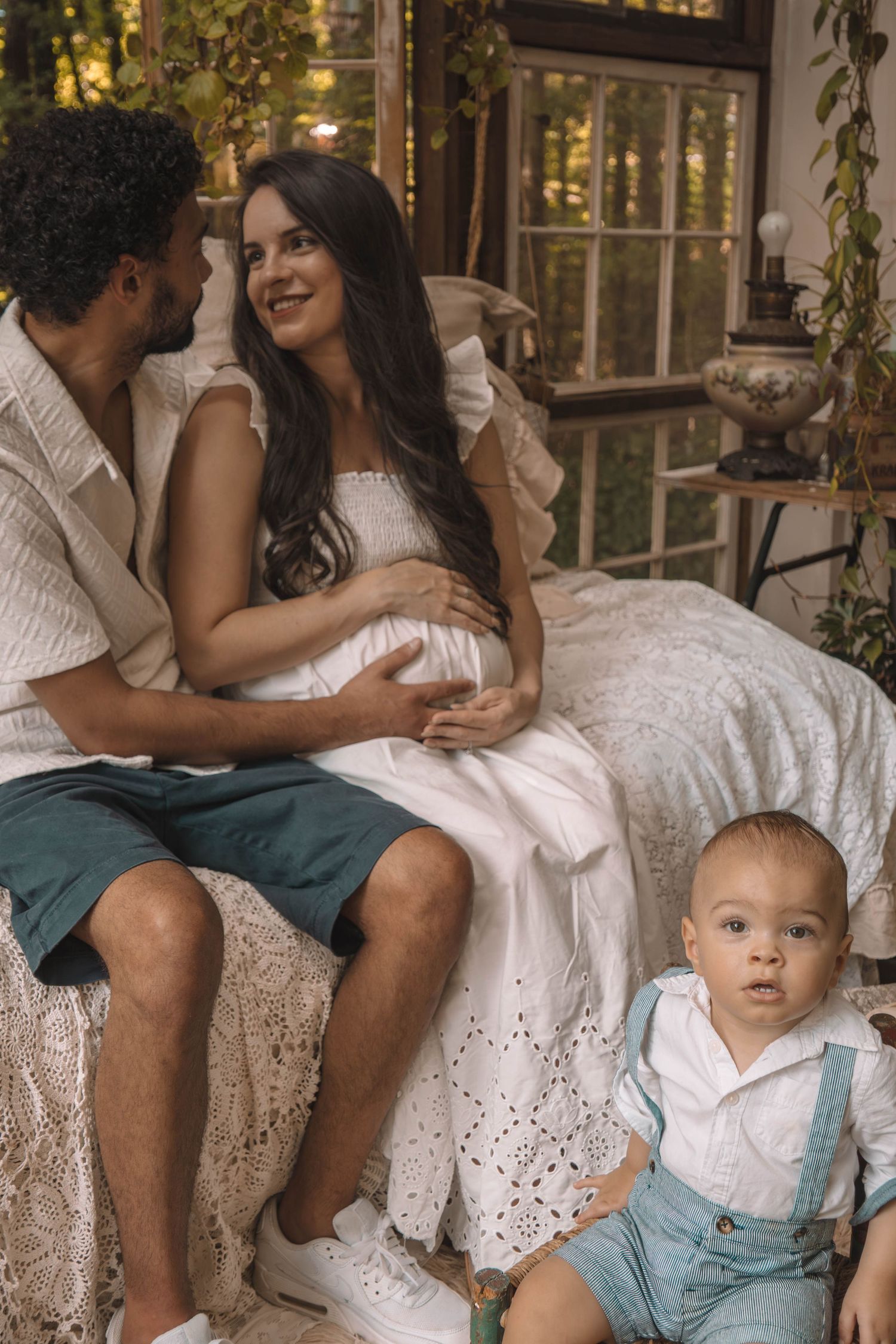 Rustic outdoor family portrait on a white lace bench with vintage decor.