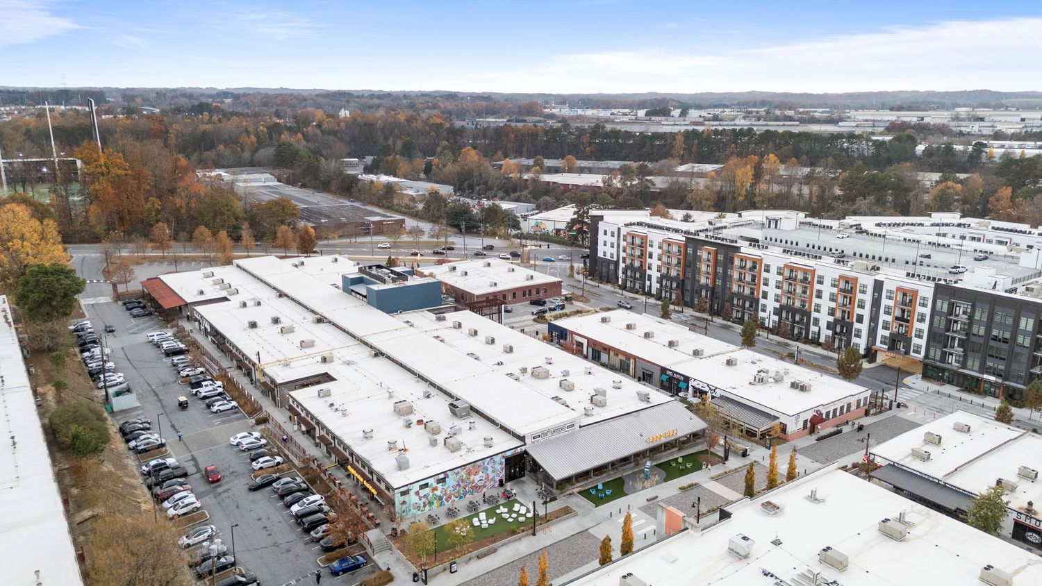 Panoramic aerial view of apartment buildings and parking lots in a suburban area during autumn season.