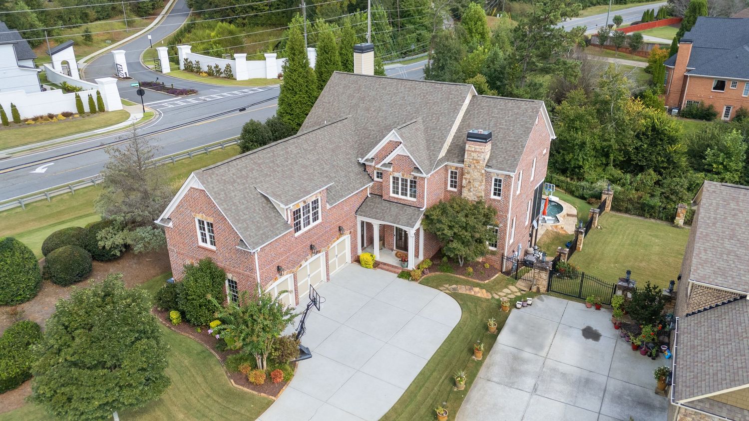 Aerial view of residential homes with driveways and landscaped yards in a suburban neighborhood.