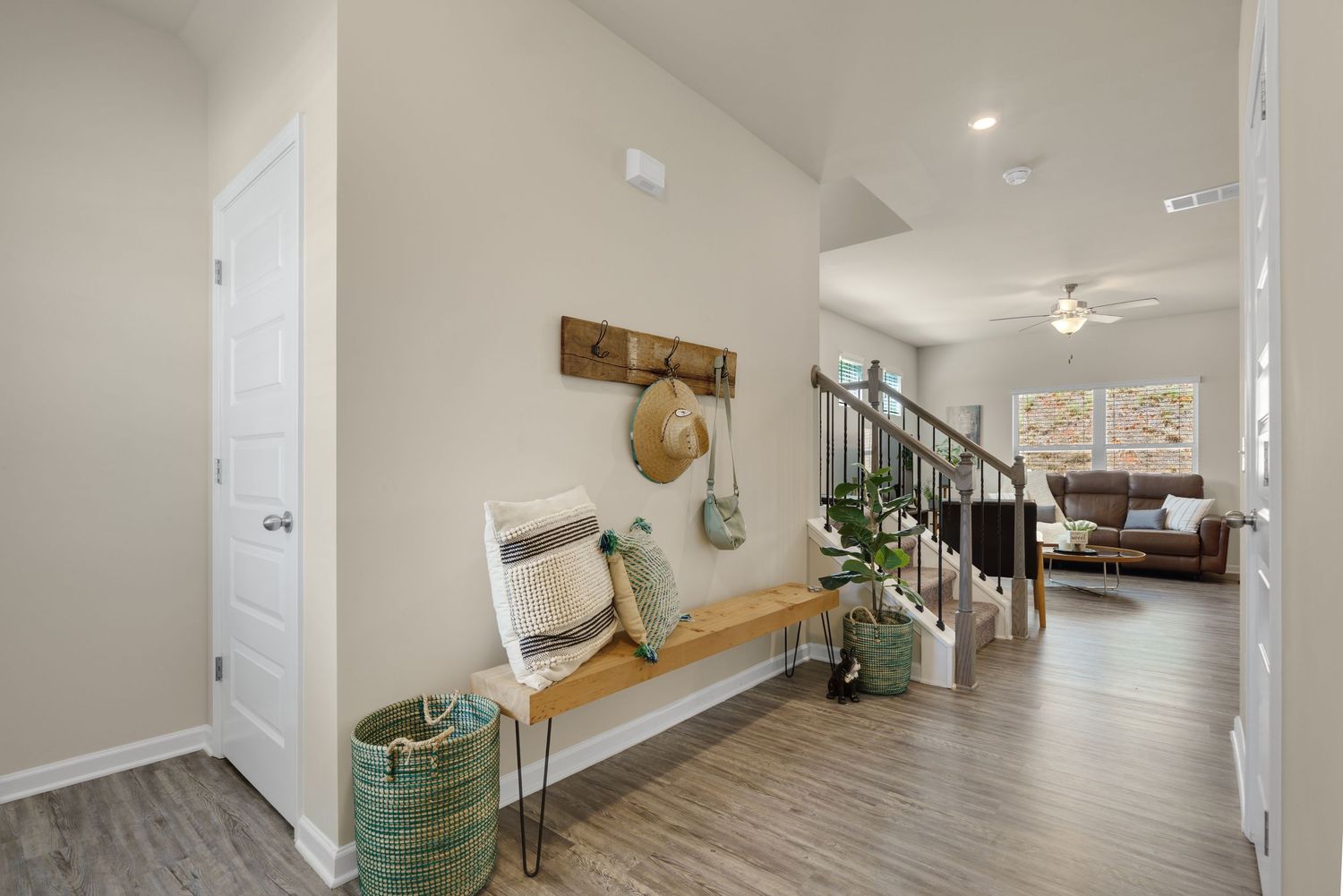 Modern white hallway with recessed lighting, hardwood floors, and multiple doorways leading to different rooms.