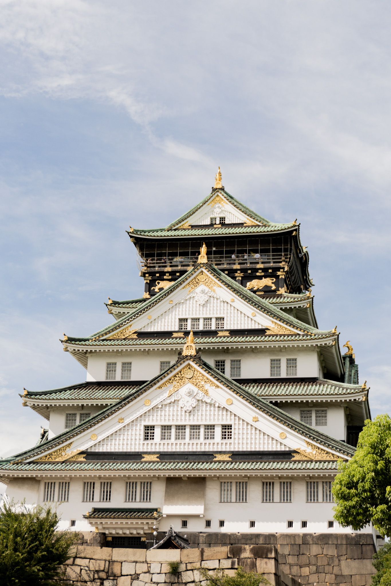 Majestic Osaka Castle featuring traditional Japanese architecture with white walls and dark tiered roofs.