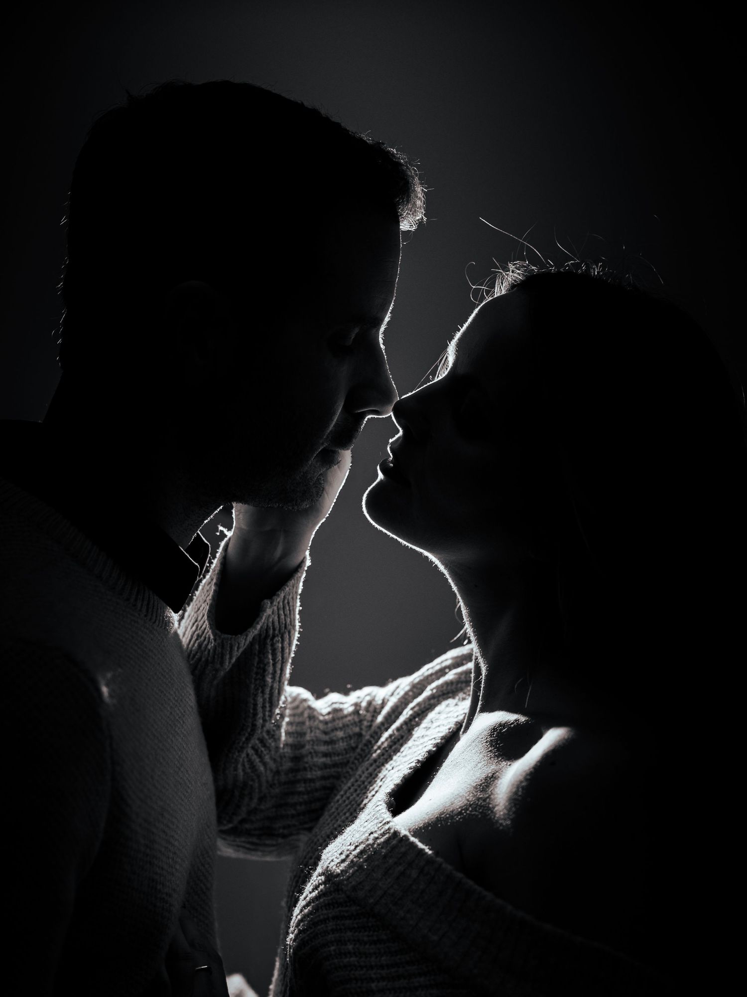A dramatic black and white portrait series showing silhouettes and rim lighting against dark backgrounds.