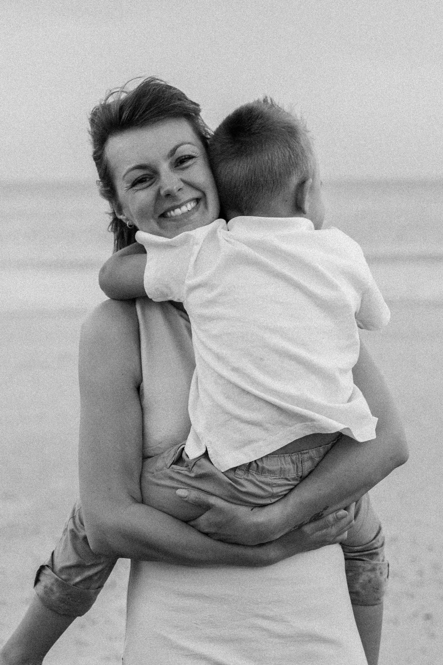 A series of black and white photos showing a tender embrace between two people outdoors.