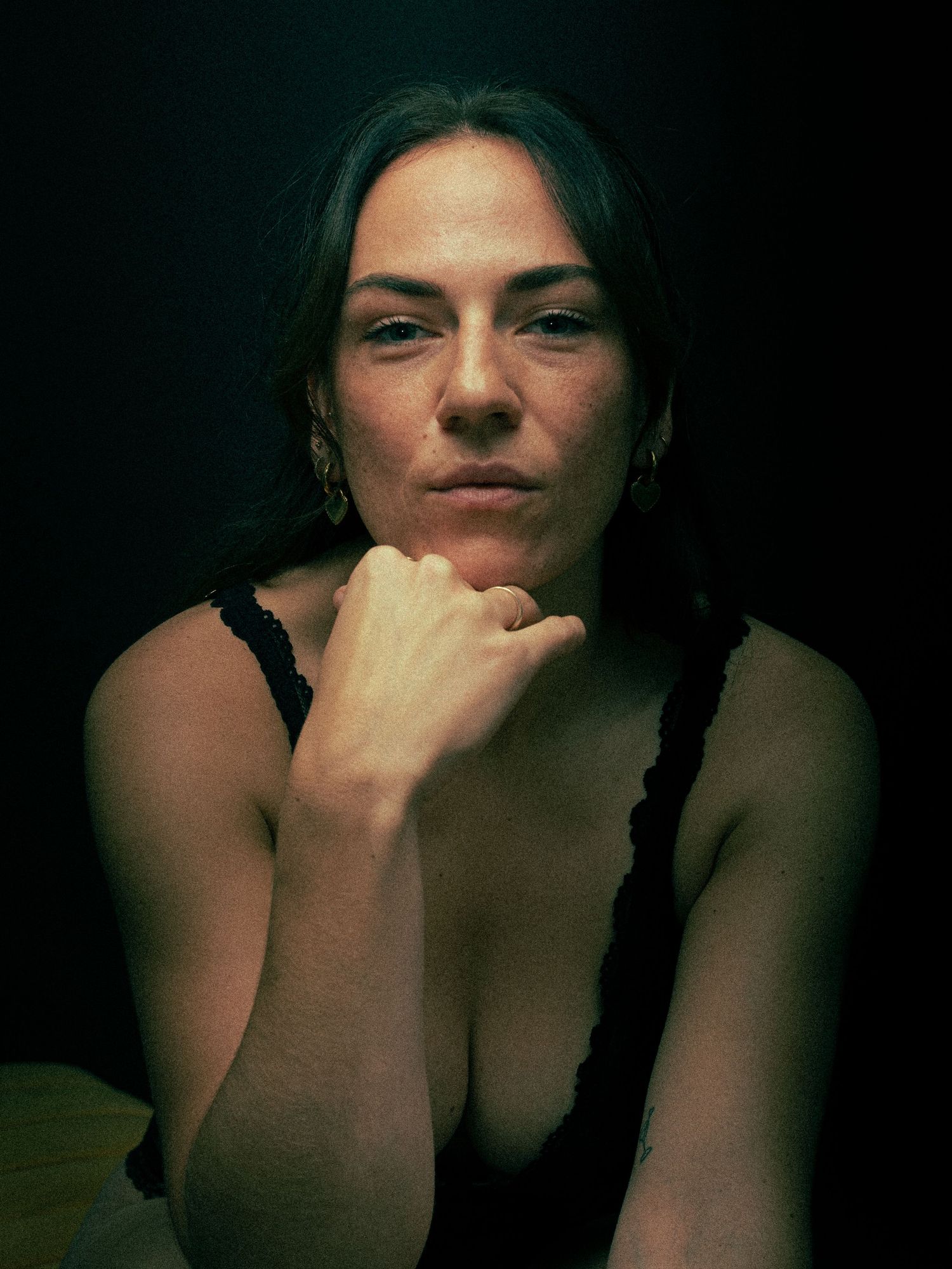 Low-light portrait series with dramatic shadows and contemplative poses.
