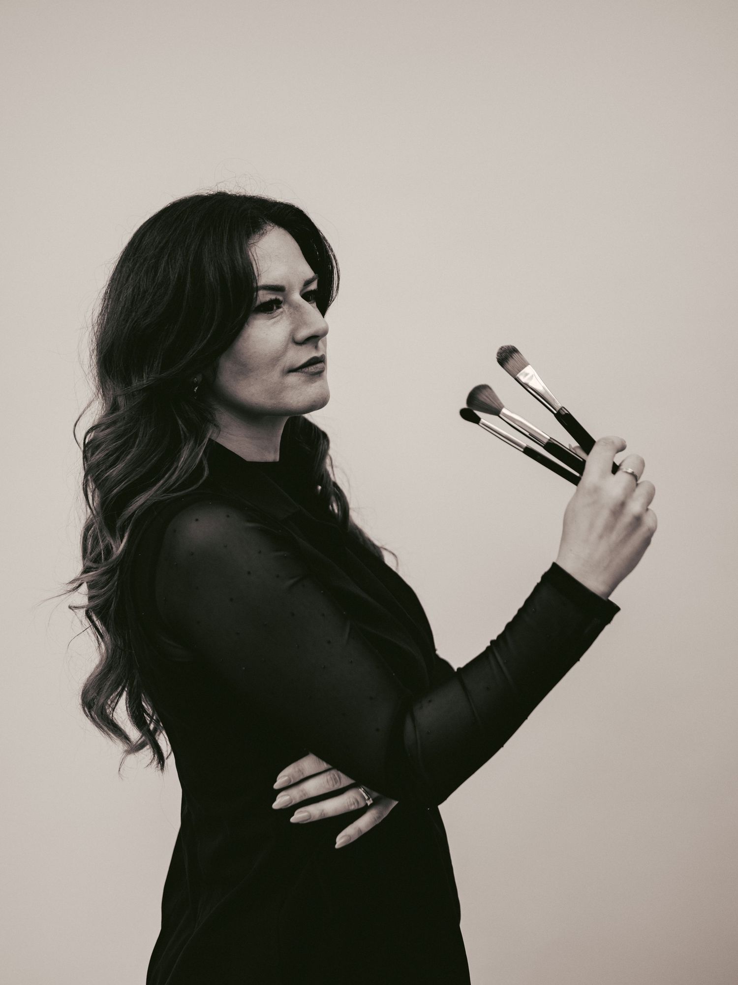 A series of black and white artistic portraits showing a person in a dark sweater posing dramatically against a light background.