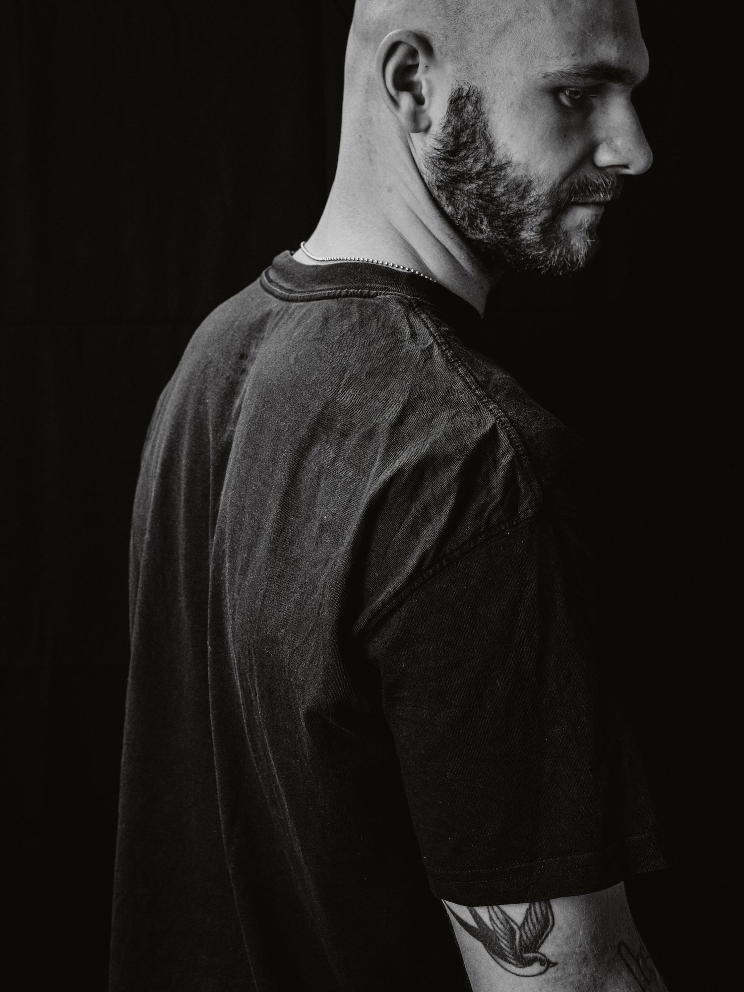 A series of black and white profile portraits showing a bearded man in a dark shirt against a dark background.