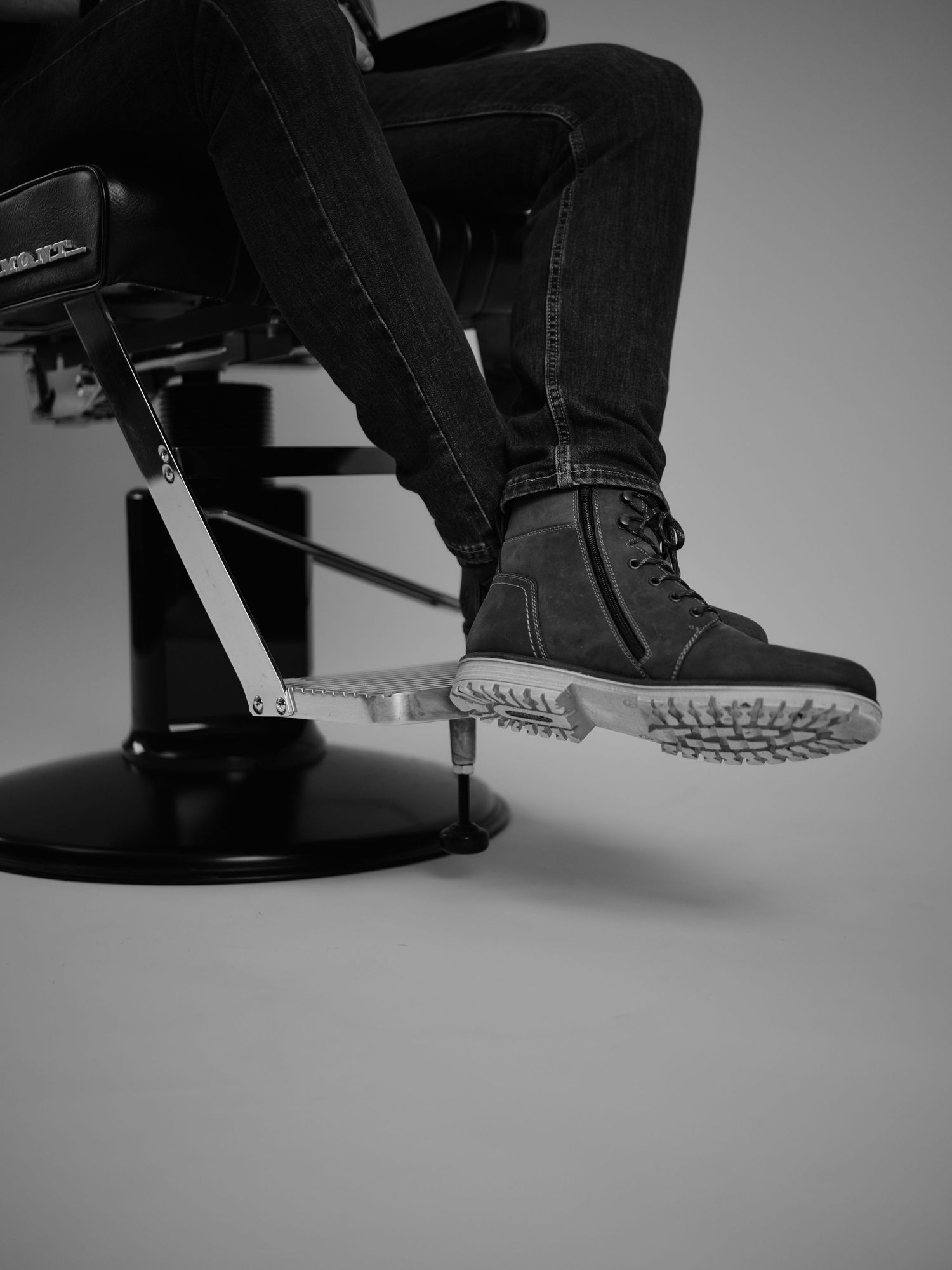 Black and white photo series showing close-up views of boots stepping and walking on a dark surface.