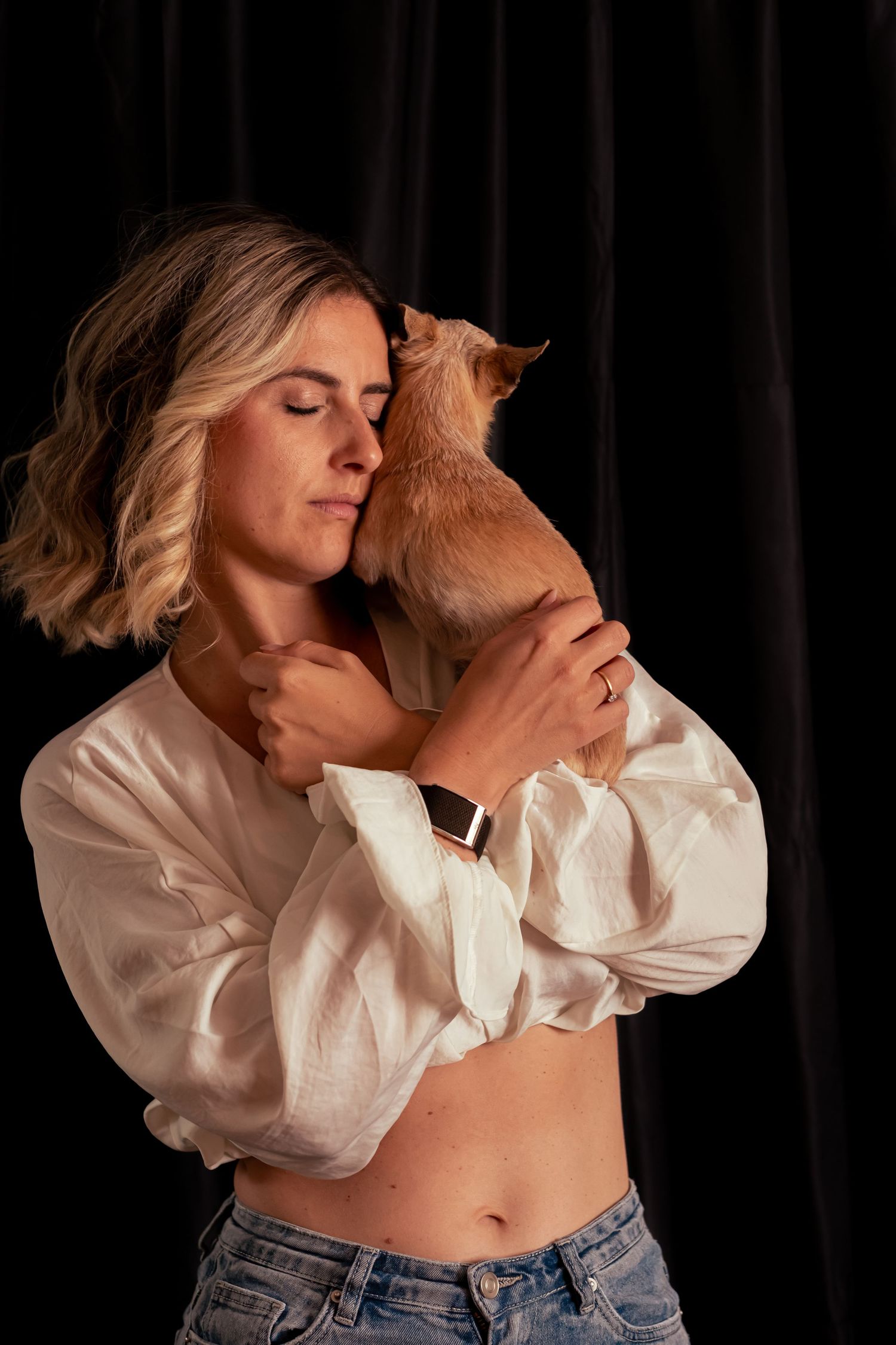 Artistic portrait series showing person in white blouse and jeans against dark background.