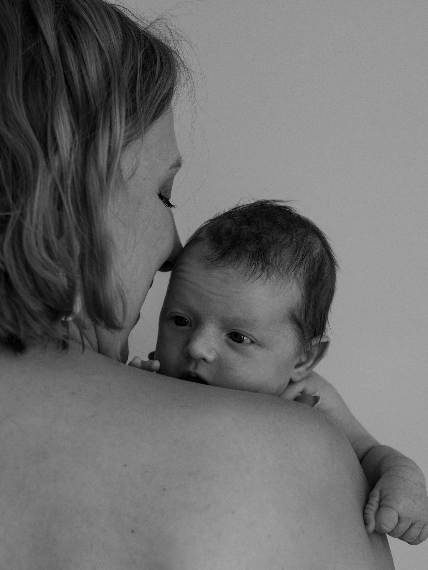 Black and white series showing intimate bonding moments between parent and baby.