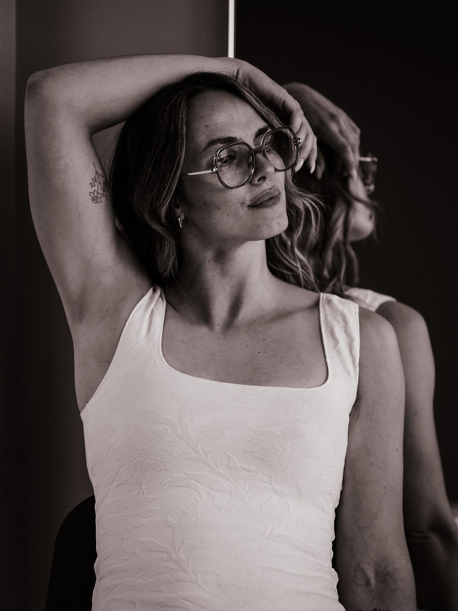 Minimalist studio portraits in white tank top with artistic angles.