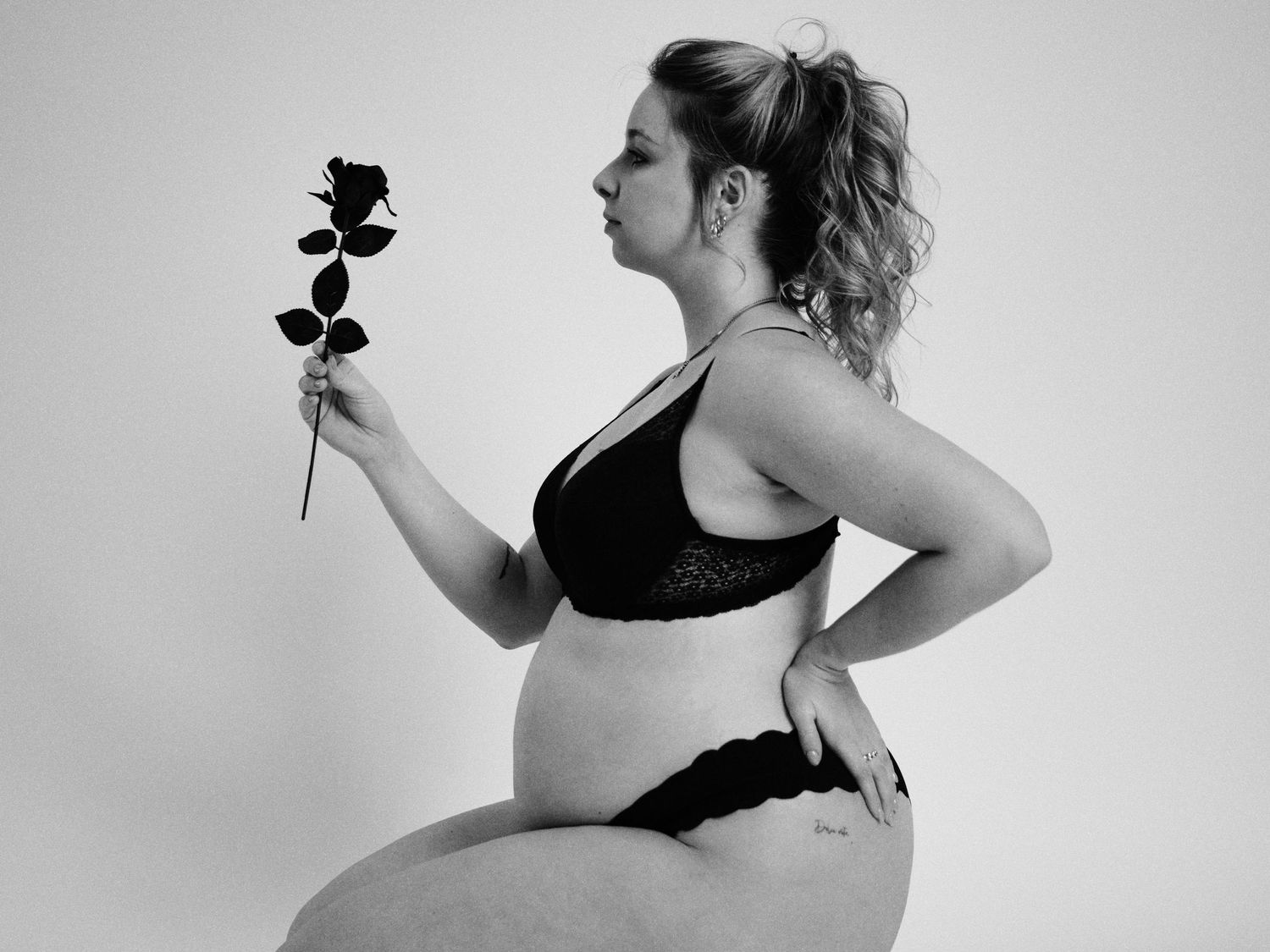 Black and white silhouette series shows person holding single rose in artistic poses against white backdrop.