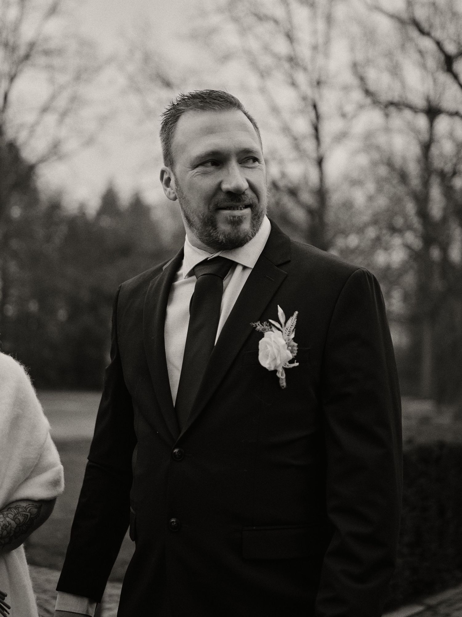 A series of black and white portraits showing a person in formal attire with a boutonniere during a wedding celebration.