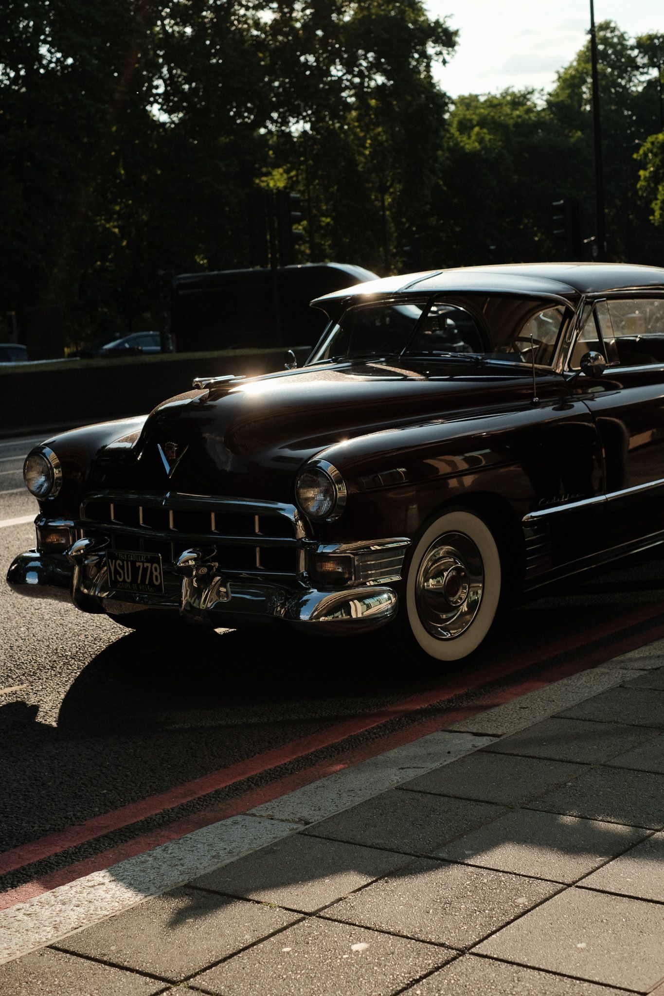 Row of vintage black classic cars parked on a street.