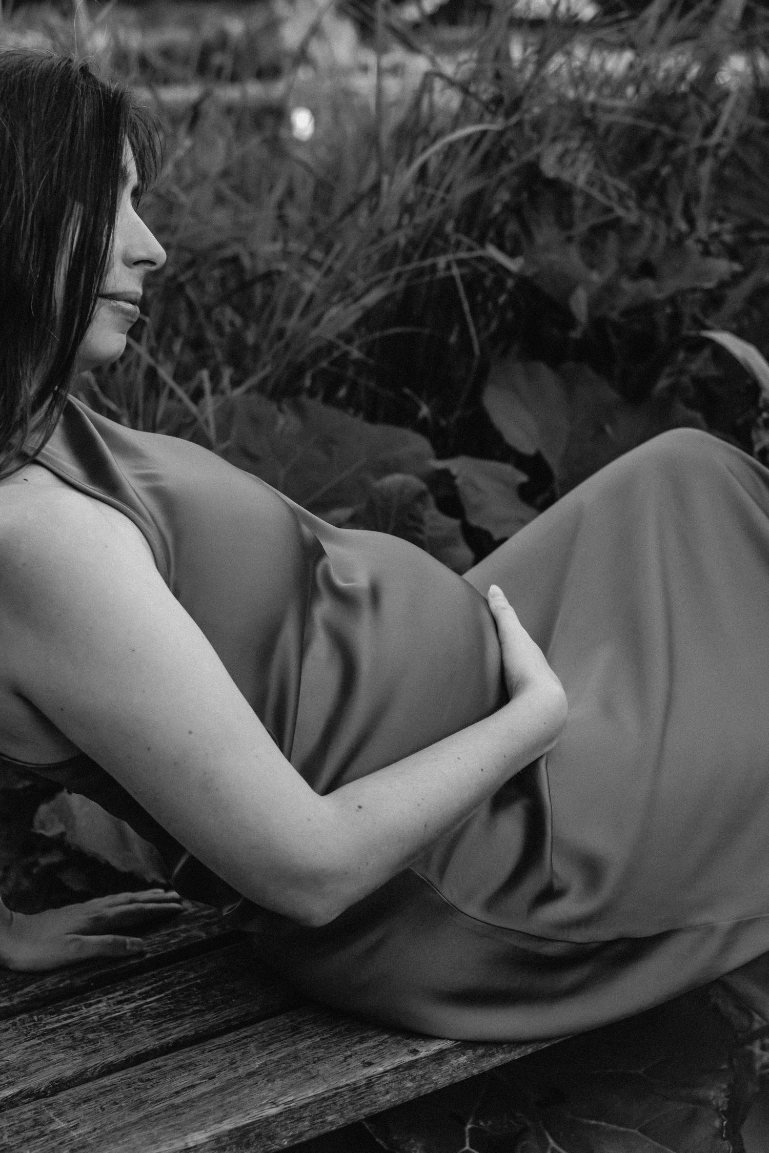 Artistic black and white maternity photos with dramatic shadows and curves.