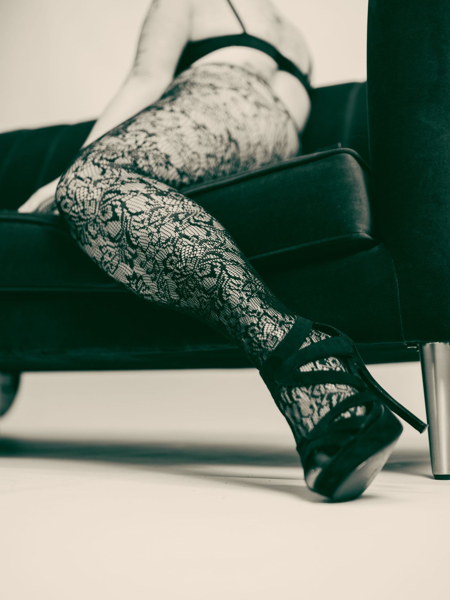 A series of close-up shots showing lace-patterned stockings and black heels against a dark background.