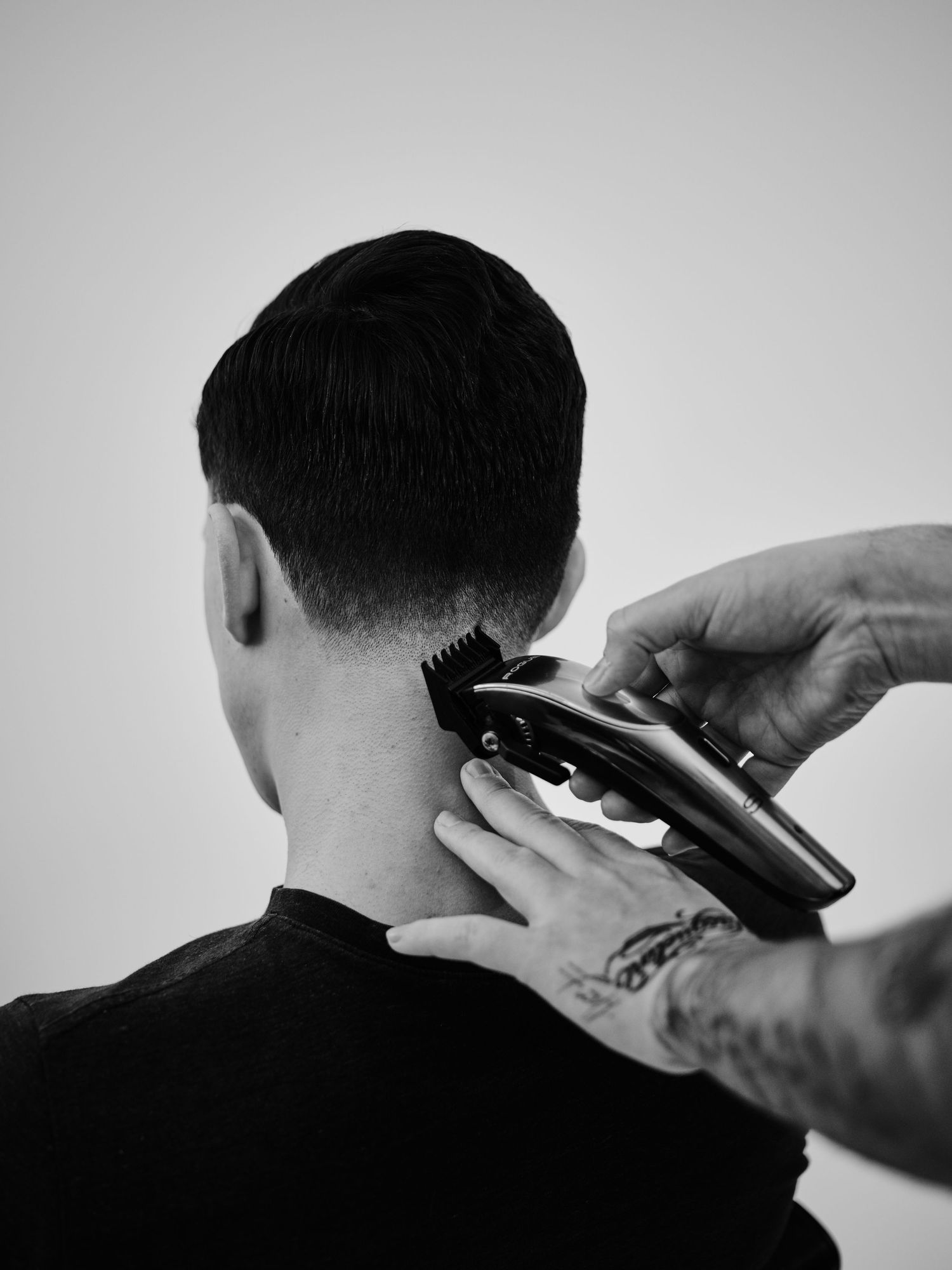 A step-by-step sequence showing a haircut in progress with electric clippers being used on dark hair against a white background.