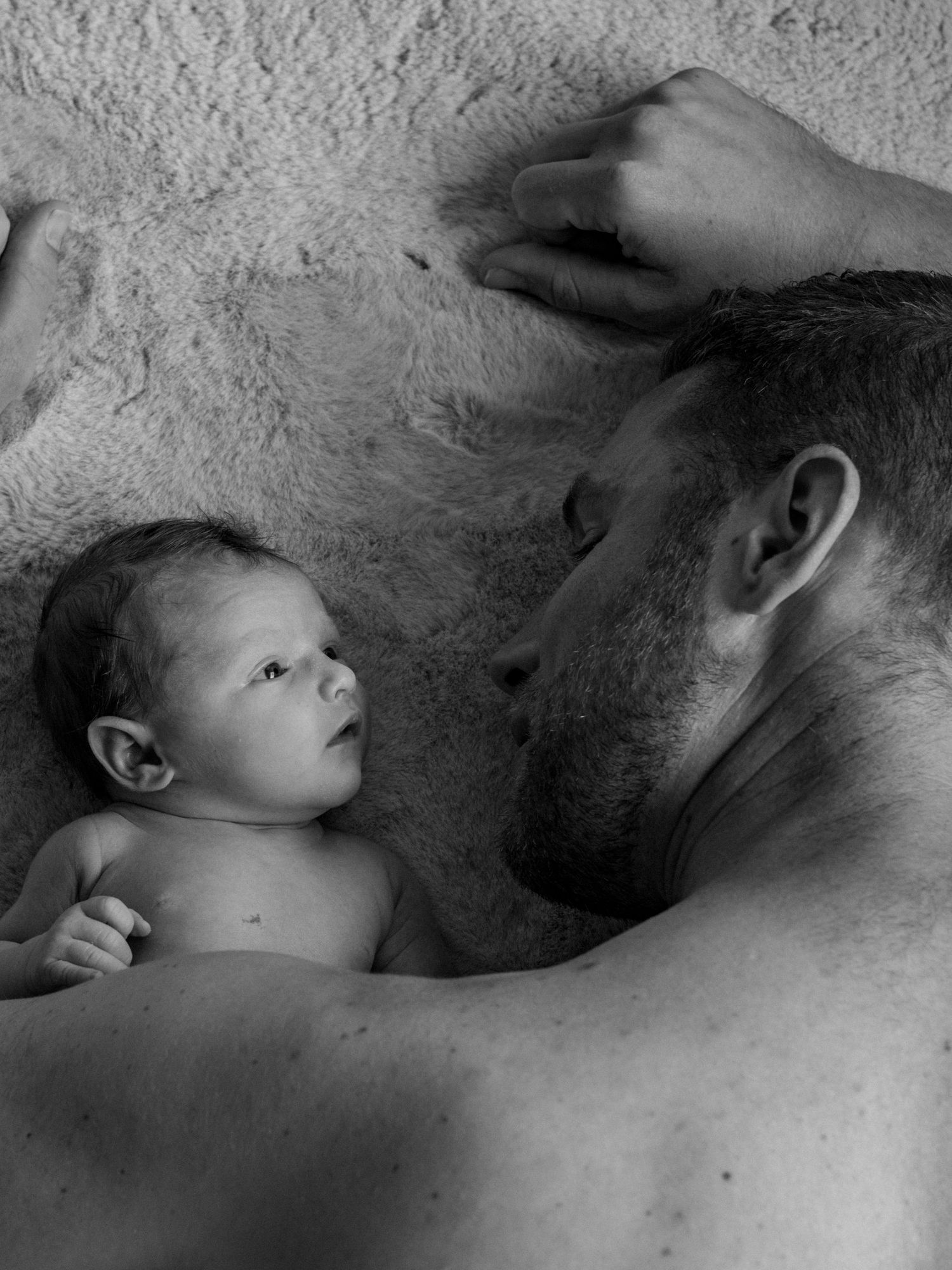 Black and white close-up series showing tender moments between parent and newborn.