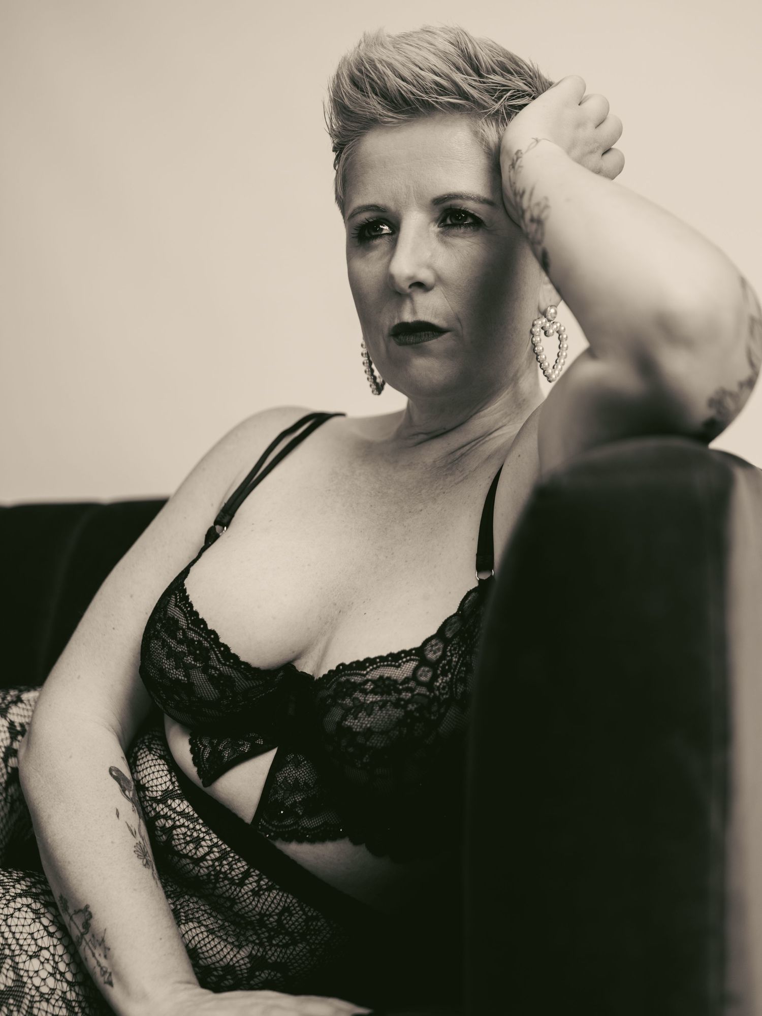 Artistic black and white boudoir photo series showing a figure in lace lingerie posing against a light background.
