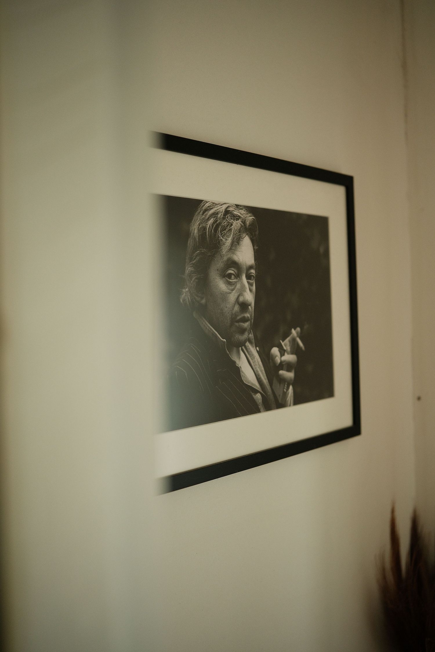 Series of black and white artistic photographs displayed on a gallery wall showing dramatic portraits.