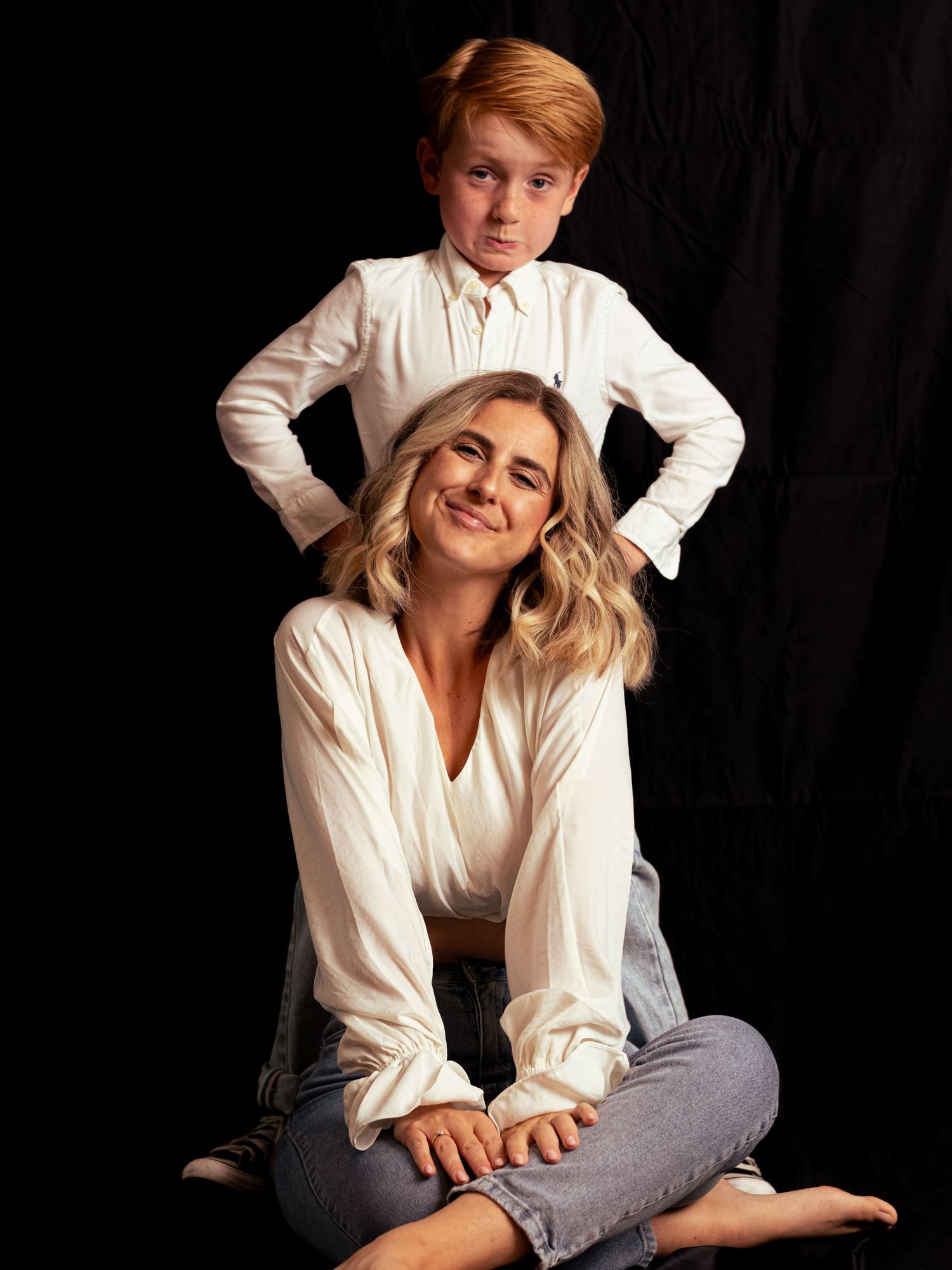 Casual portrait session with subjects in white shirts against black background.