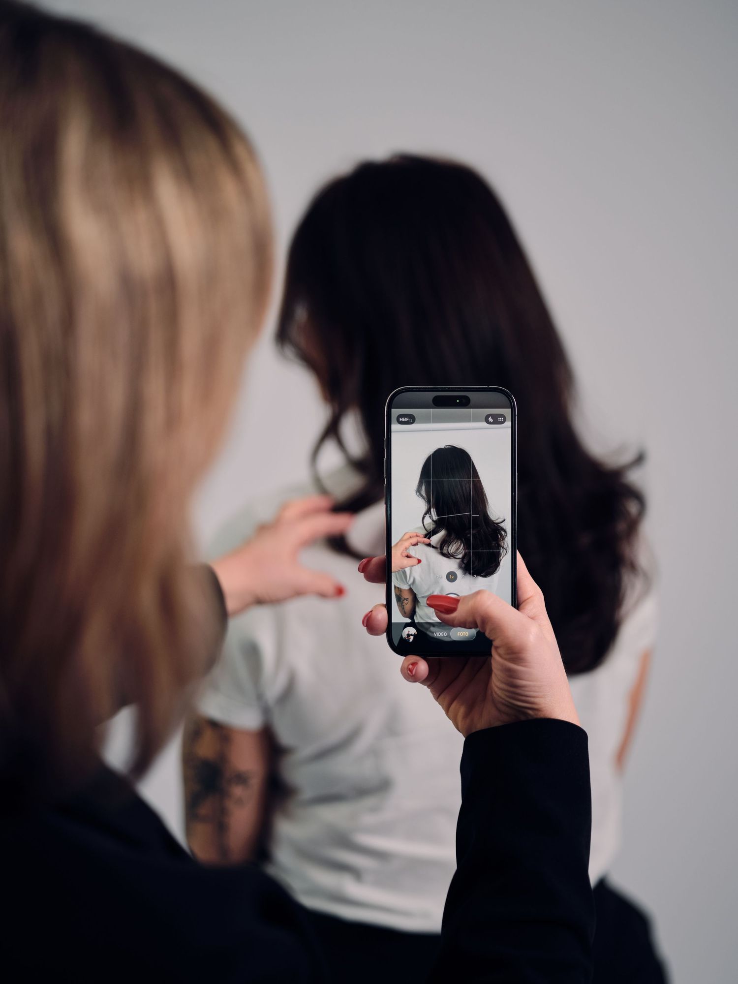 A sequence of photos showing someone taking pictures with a smartphone camera from behind another person.