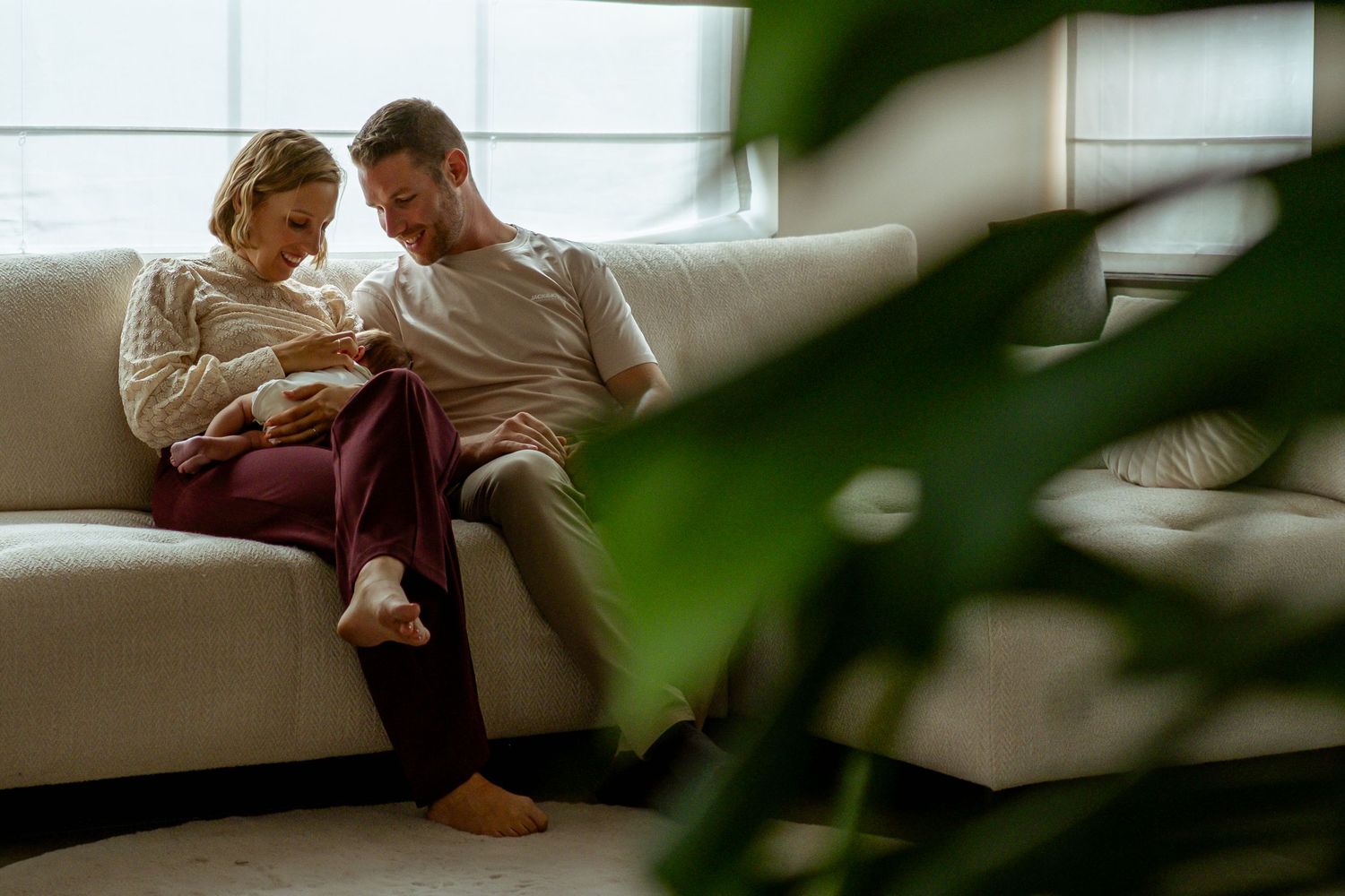 Family sharing quiet bonding moments together on white couch with natural lighting.
