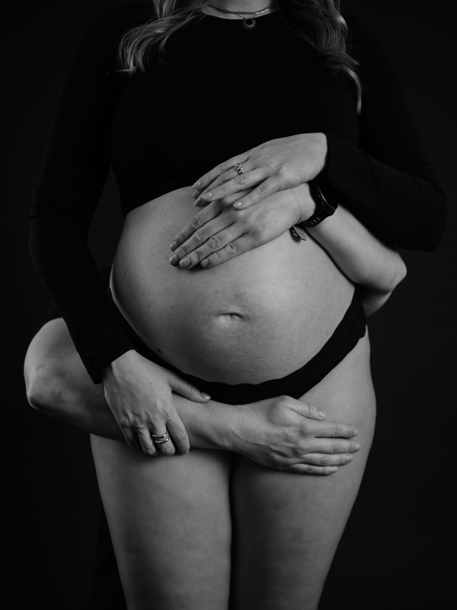 Black and white artistic photo series showing hands gently caressing a bare torso in dramatic lighting.