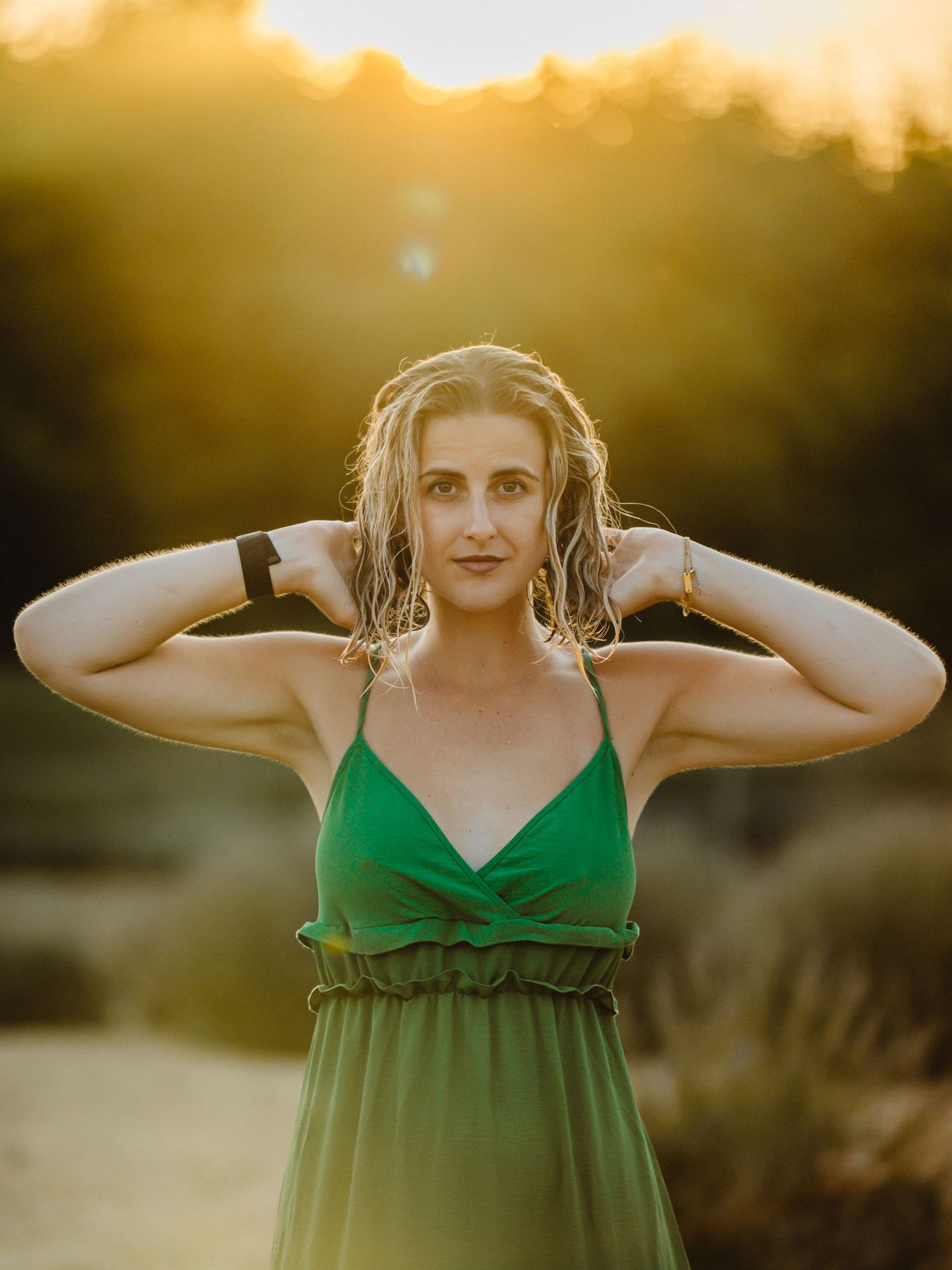 Summer portrait in green dress against golden sunset backdrop.