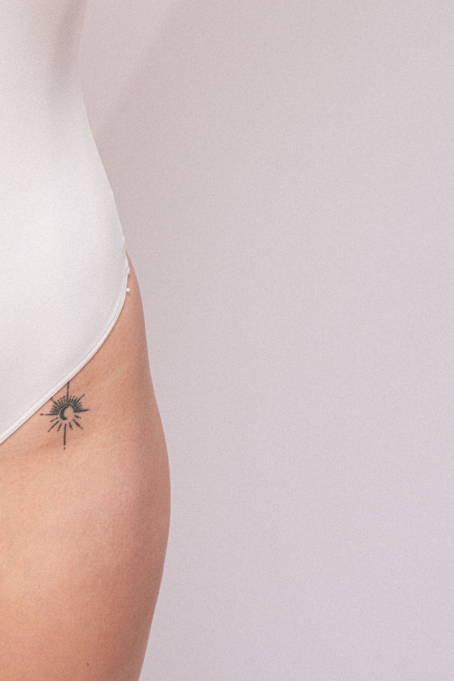 Close-up detail shots showing small tattoo against light skin and background.