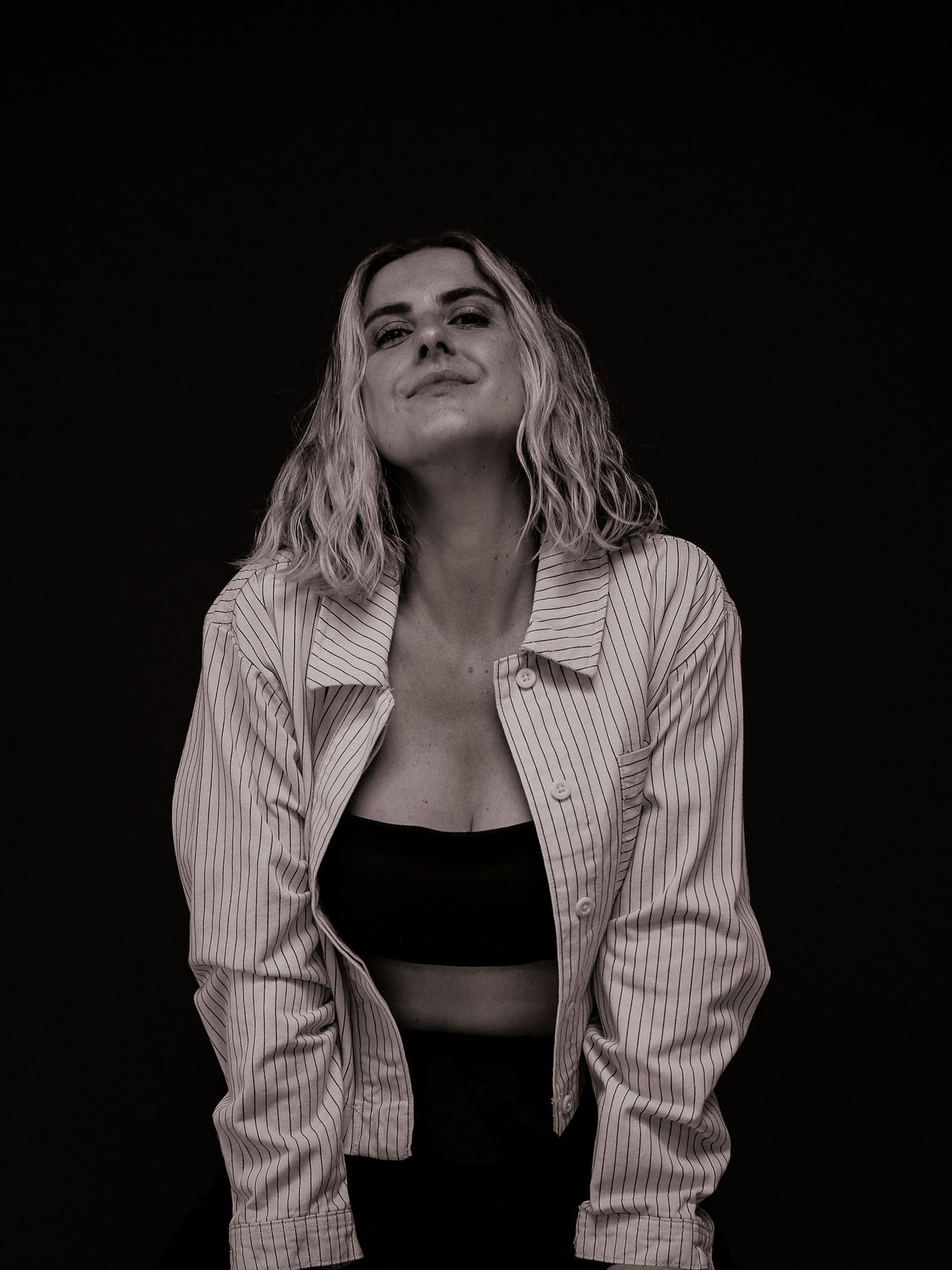 Fashion portraits featuring striped shirt and black top in moody lighting.
