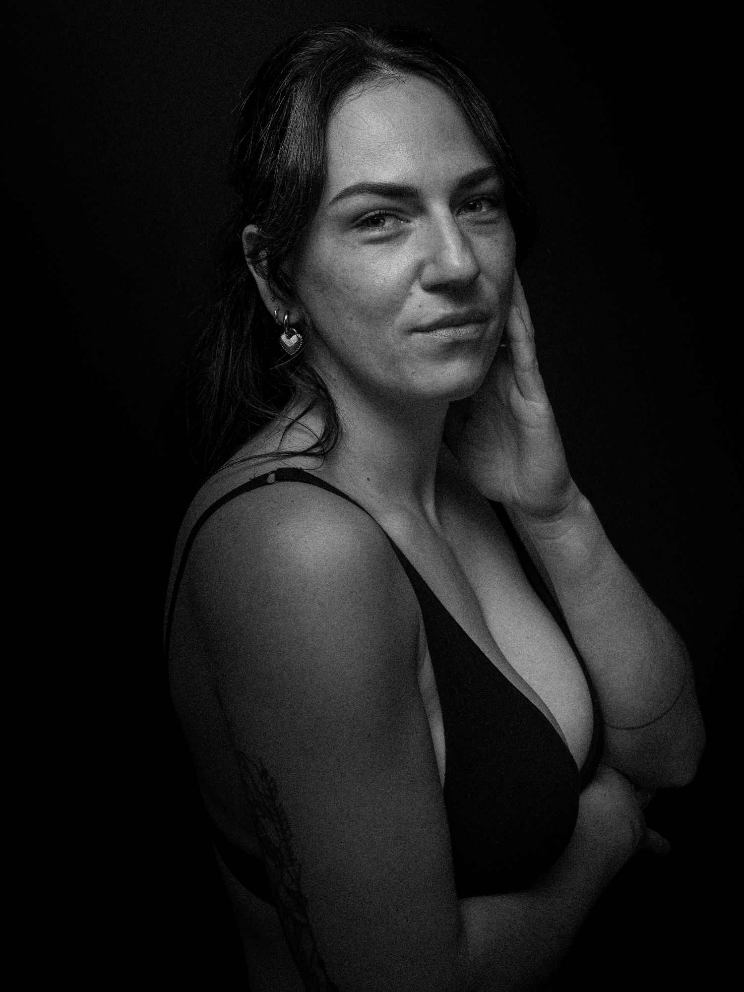 Dramatic black and white portrait series with dark background and intimate lighting.