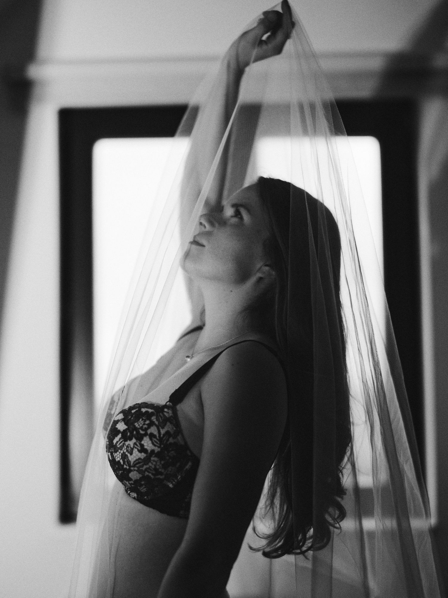 Artistic black and white boudoir photo series showing feminine silhouettes against window light and sheer curtains.