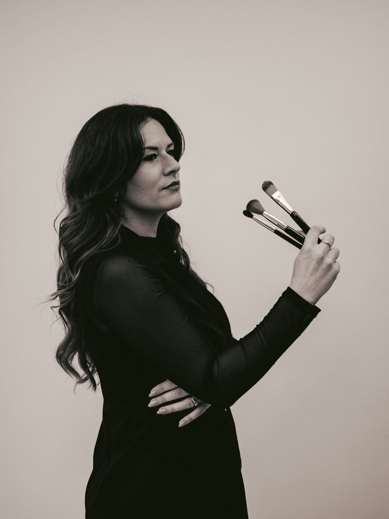 A series of dramatic black and white portraits showing a woman in dark attire posing against a light background.
