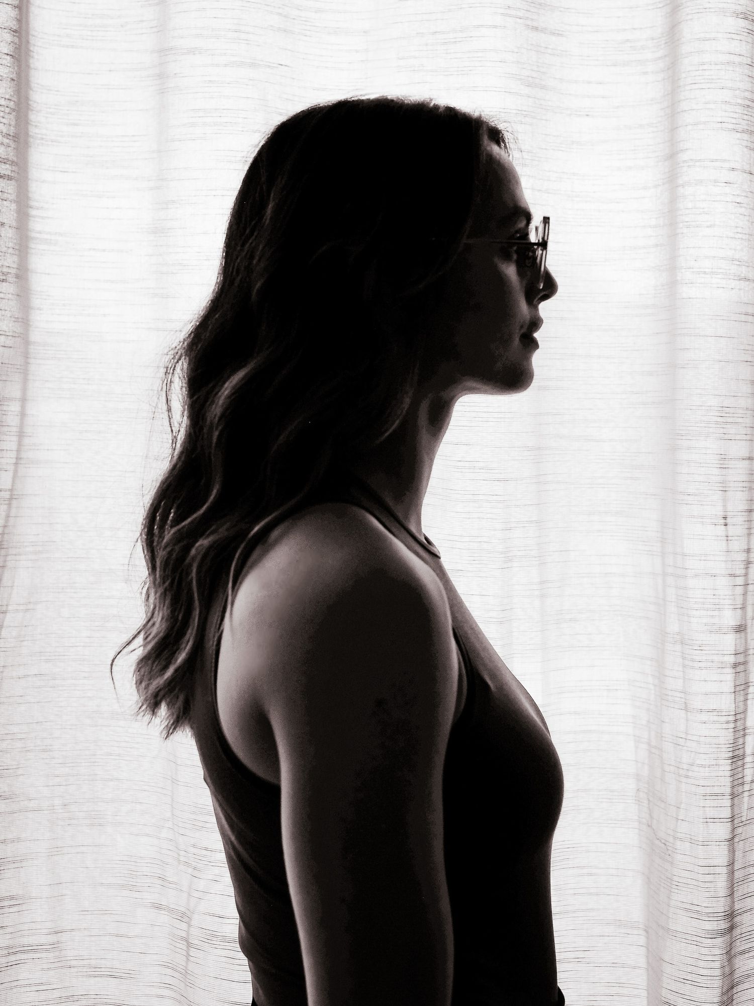 Dramatic backlit silhouettes against white curtained window.