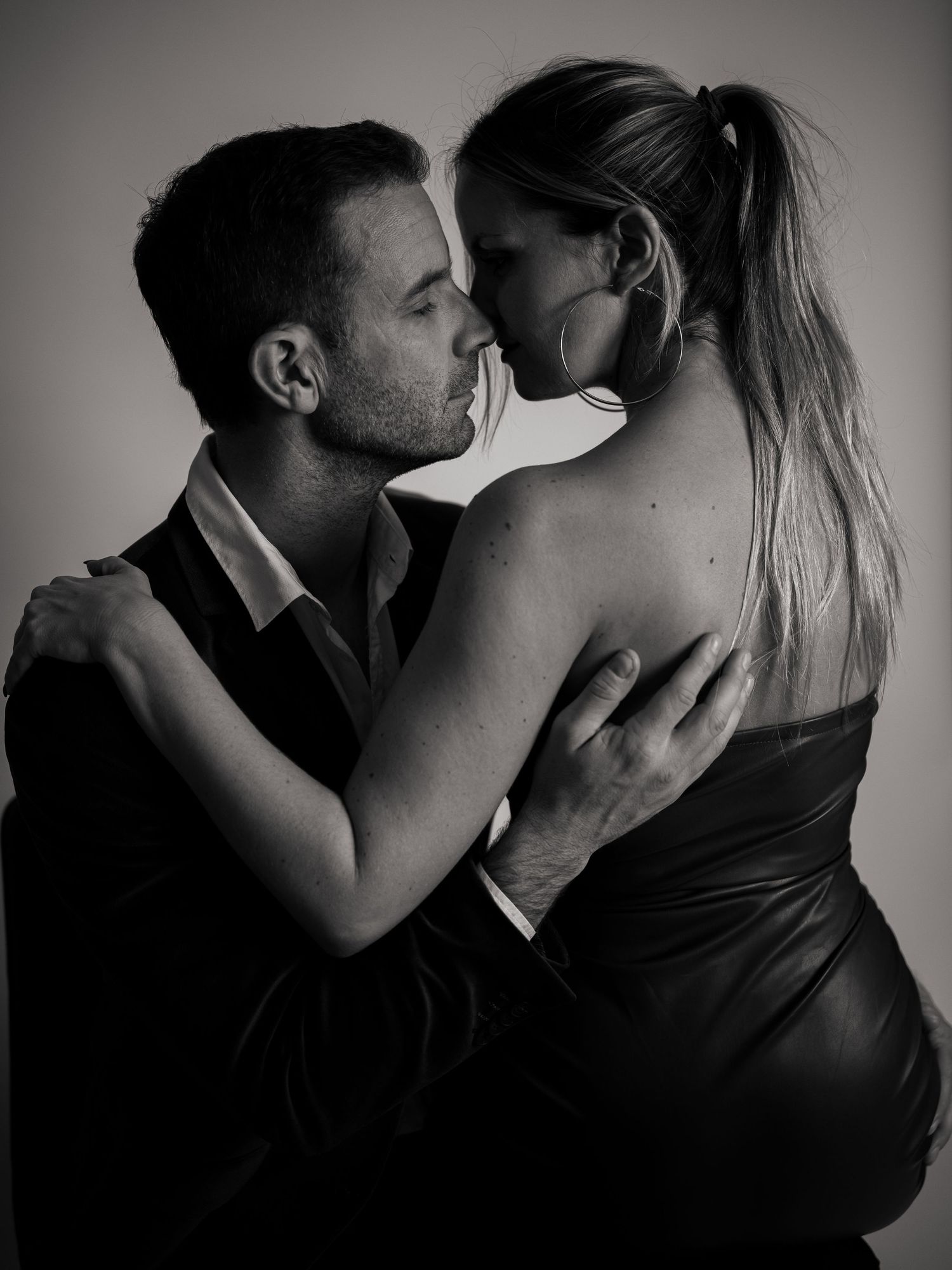 A series of black and white romantic photos showing intimate embraces and kisses between couples in dramatic lighting.
