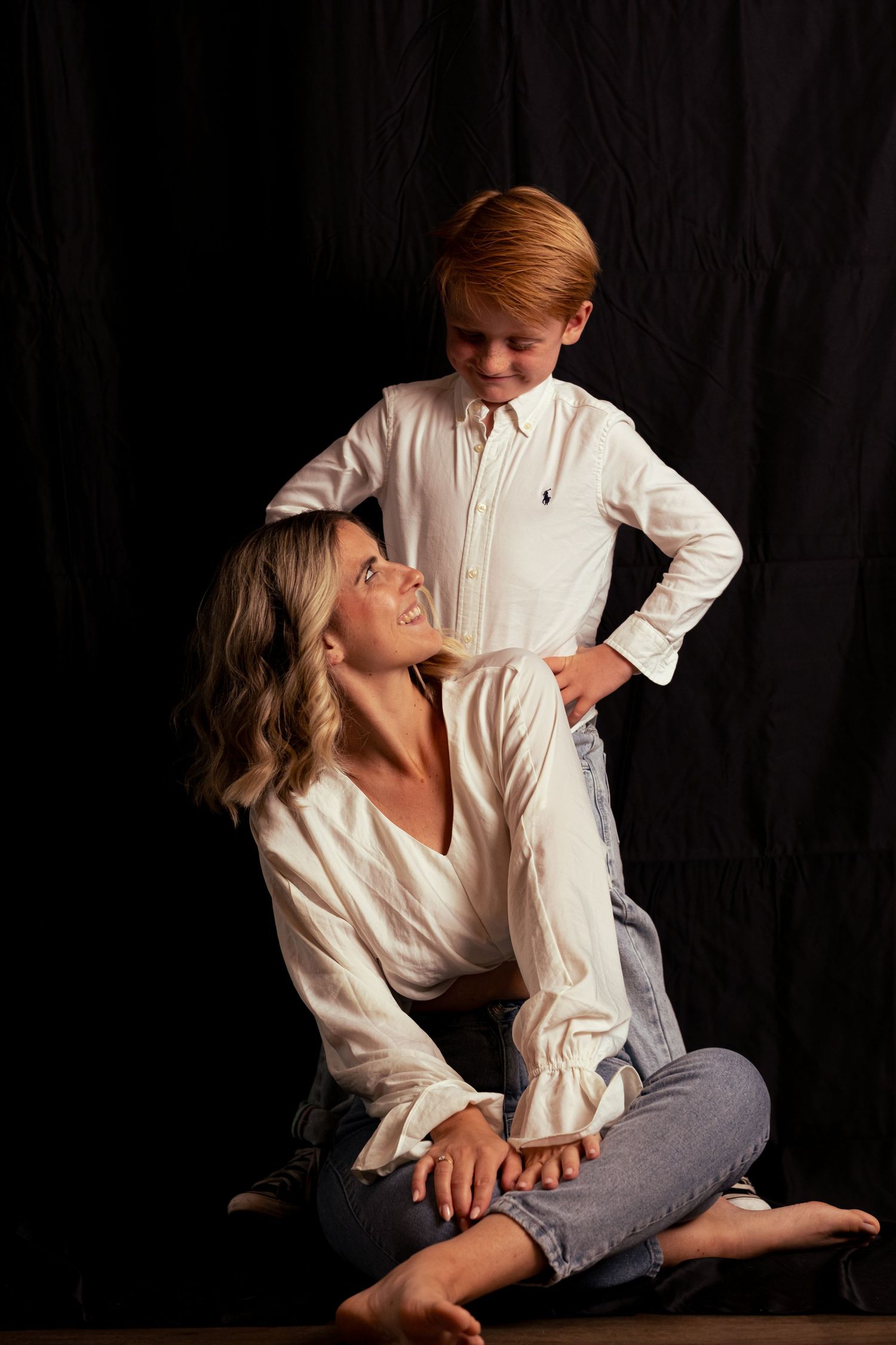 Natural lifestyle portraits with subjects in white shirts against dark backdrop.