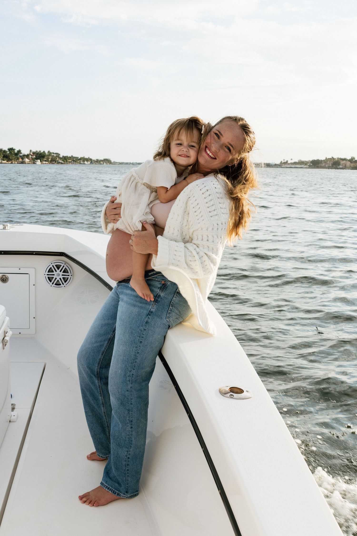 A tender moment between parent and child aboard a white boat on the water.