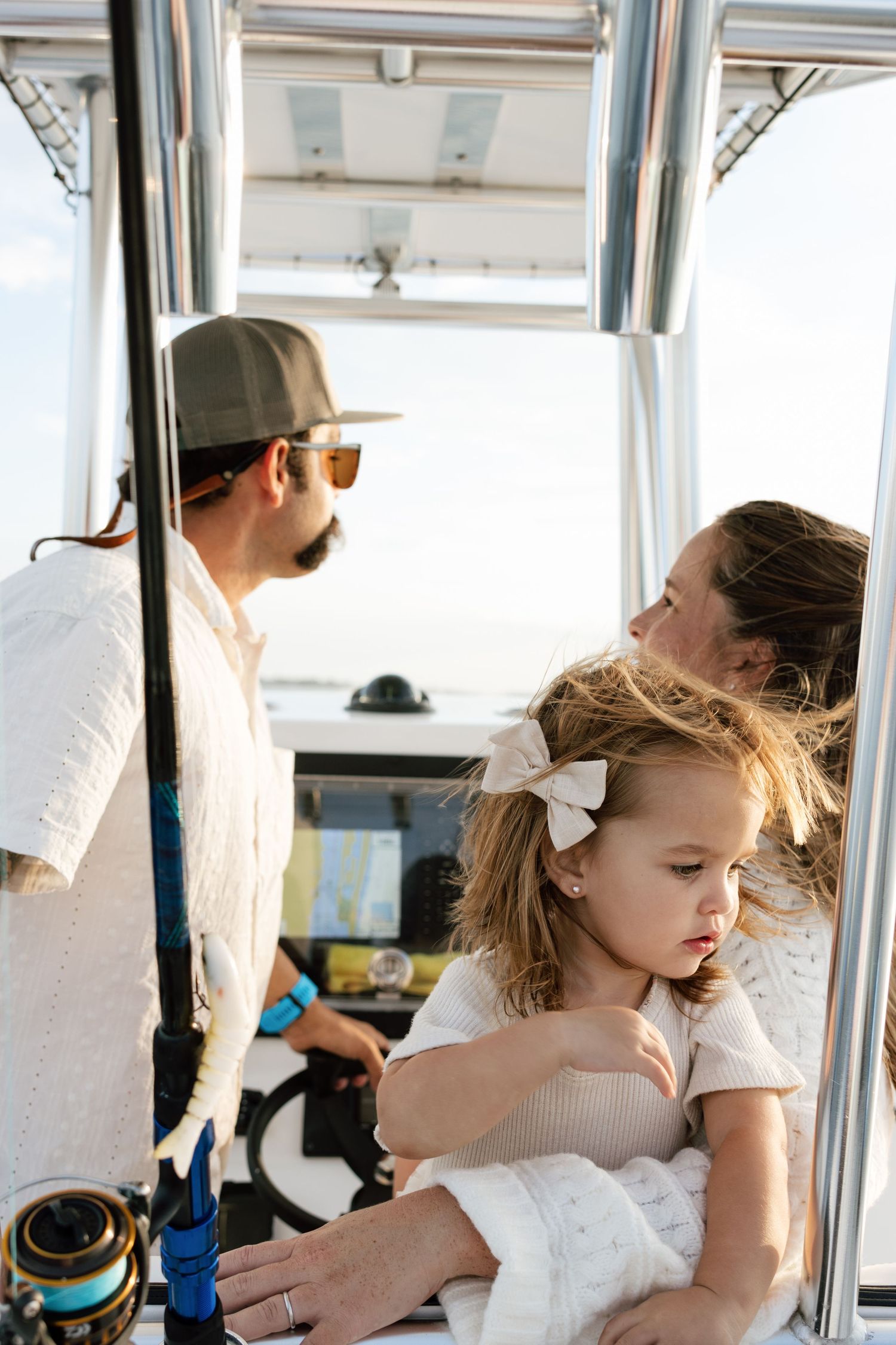 A family enjoying a boat ride together on a sunny day with white interior cabin visible.