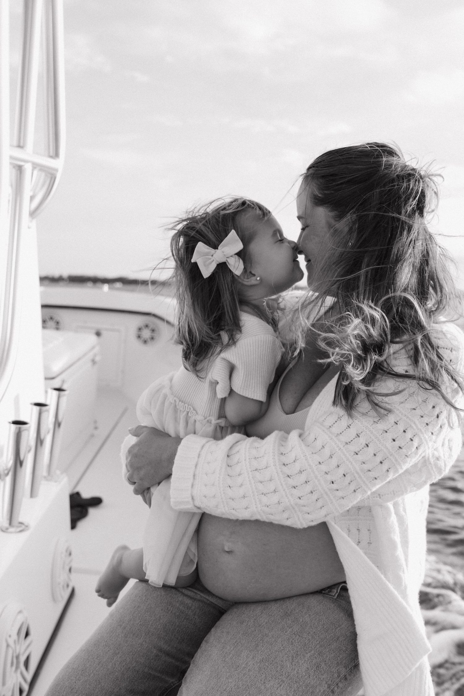 A tender moment captured in black and white between a mother and child on a boat.