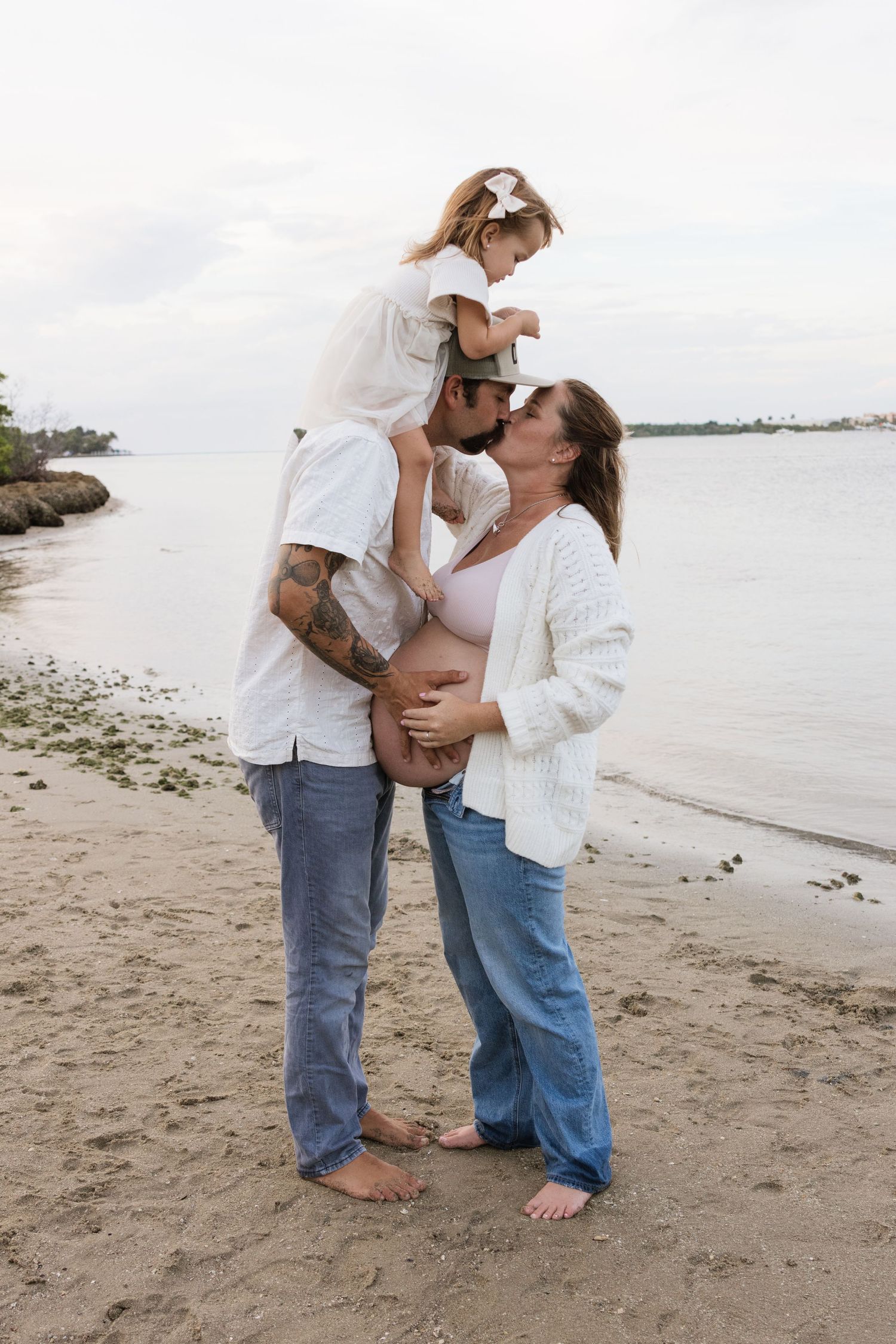 Family sharing tender moments together on a coastal beach.