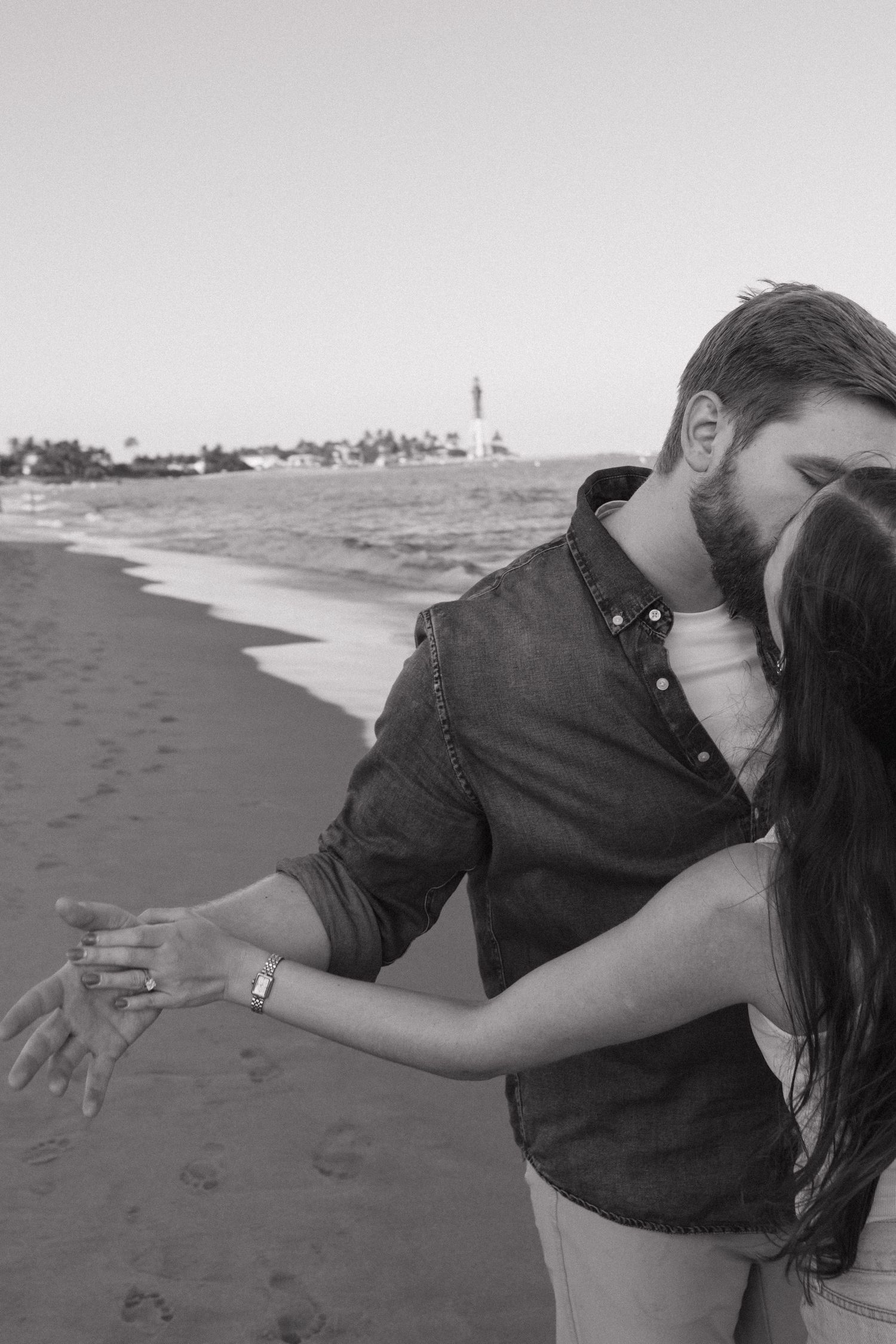 A romantic beach photoshoot featuring a couple in an intimate dance pose.