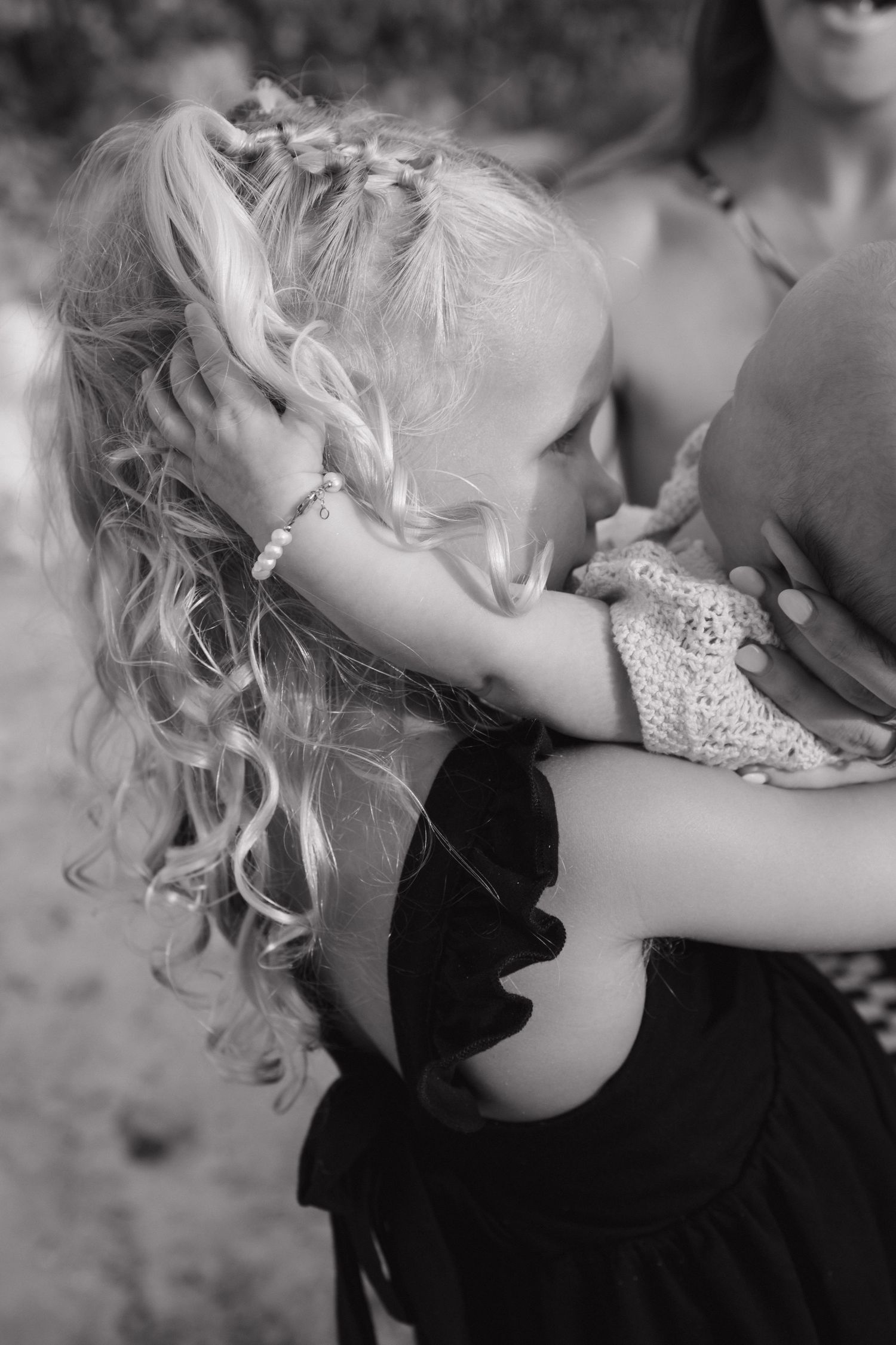 A tender black and white portrait of a couple sharing an intimate moment on the beach.