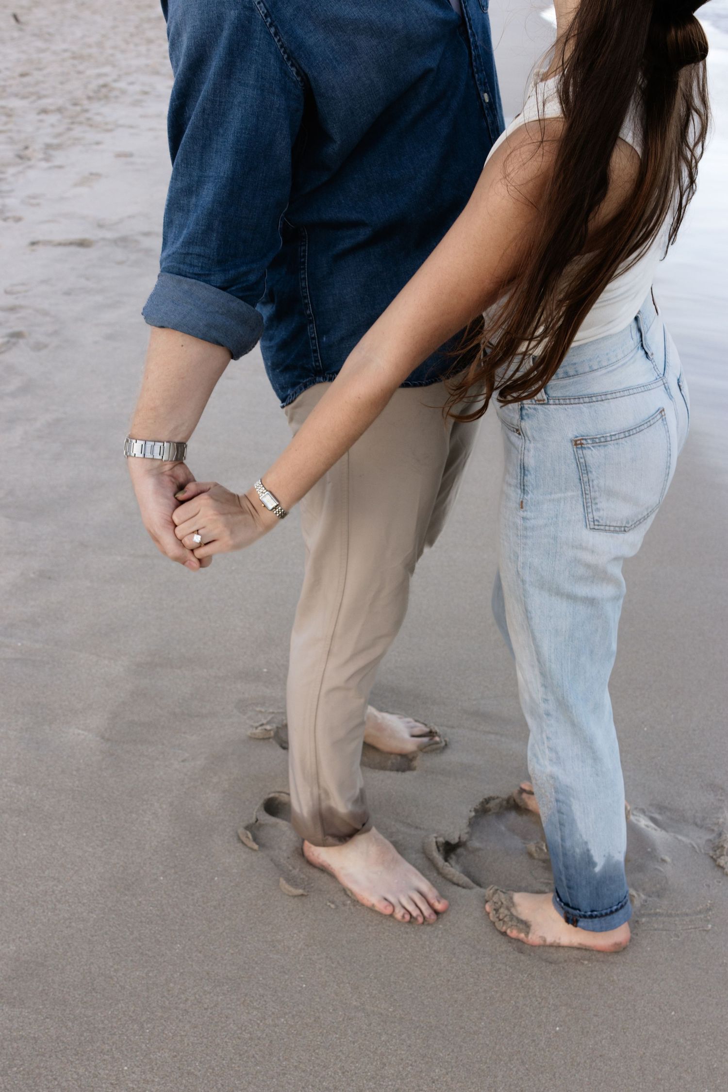 Feet in the sand during a romantic beach photoshoot.