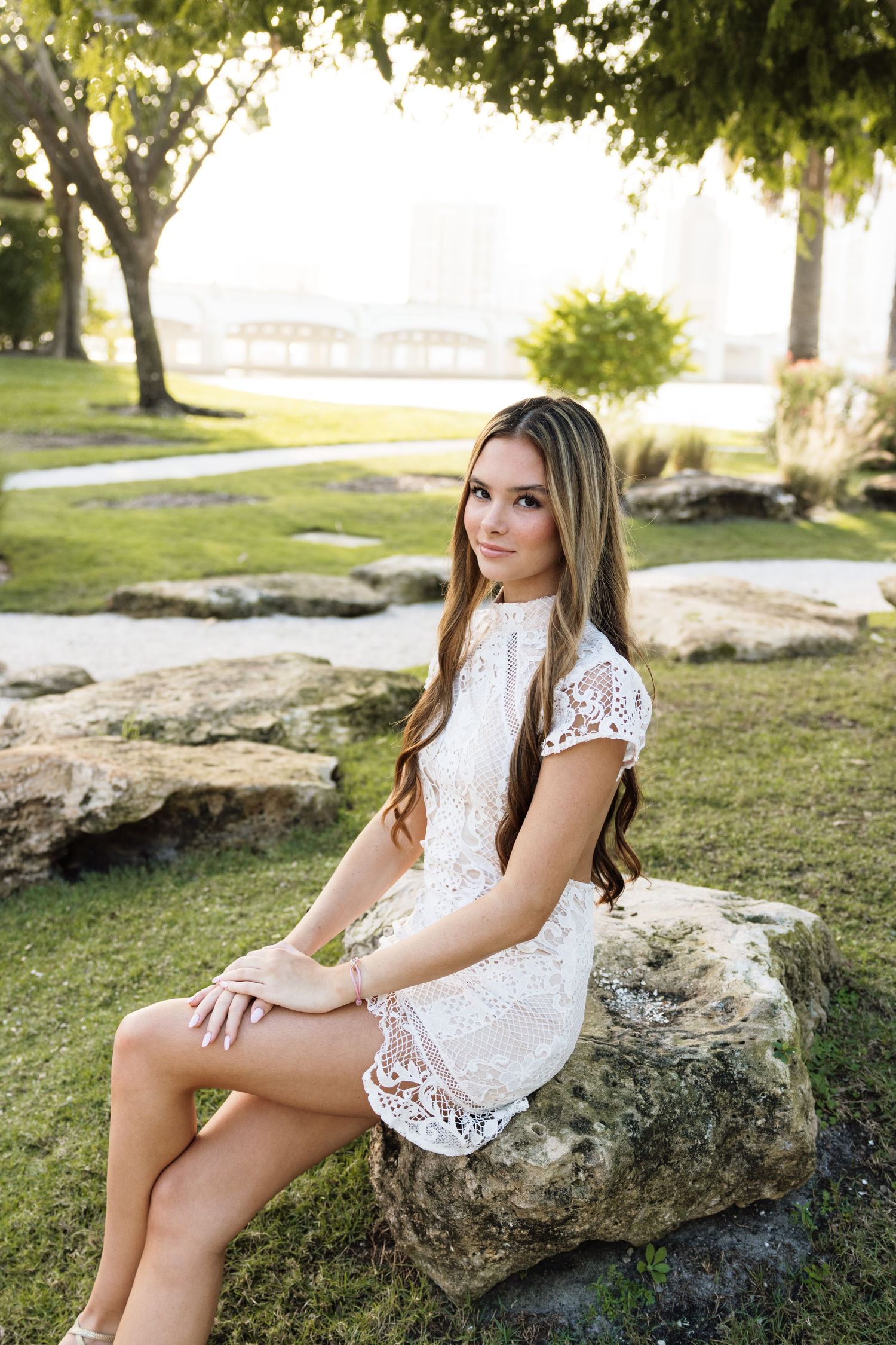 White lace outfit photographed on natural stone in park setting.
