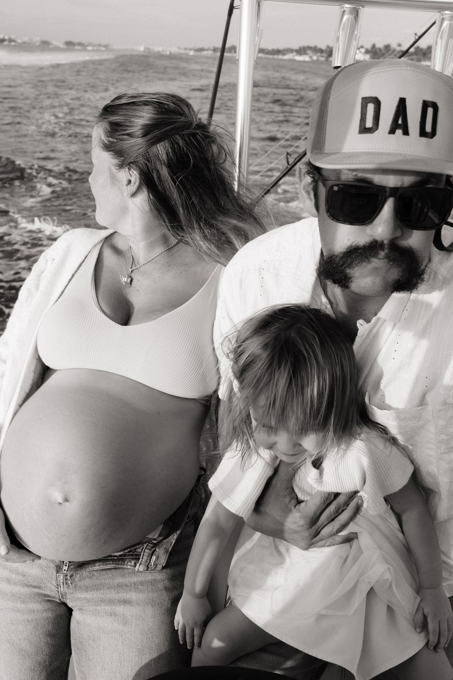 A casual family photo session on a boat with black and white filter applied.