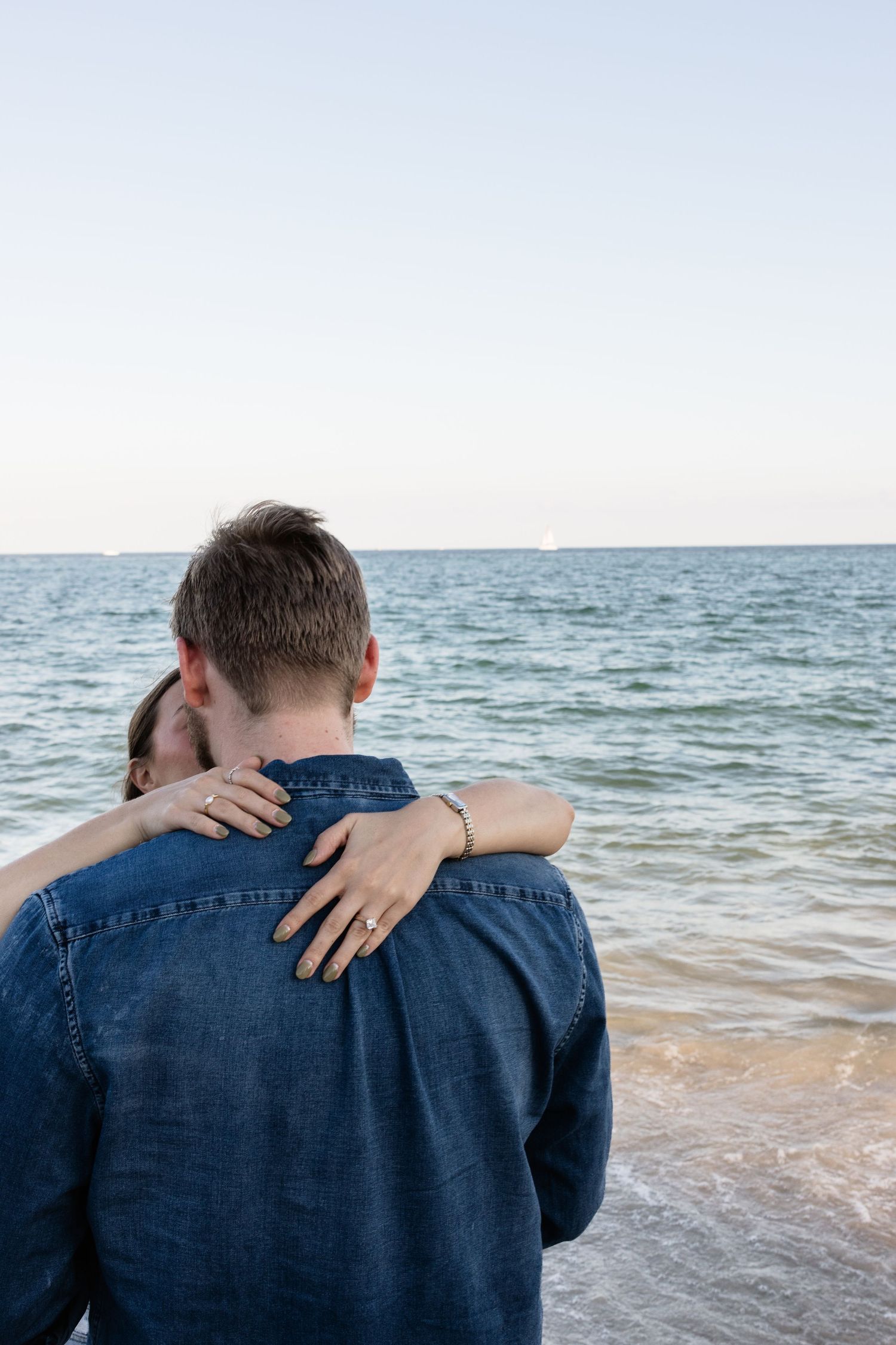 A close-up view of a denim jacket against an ocean backdrop.