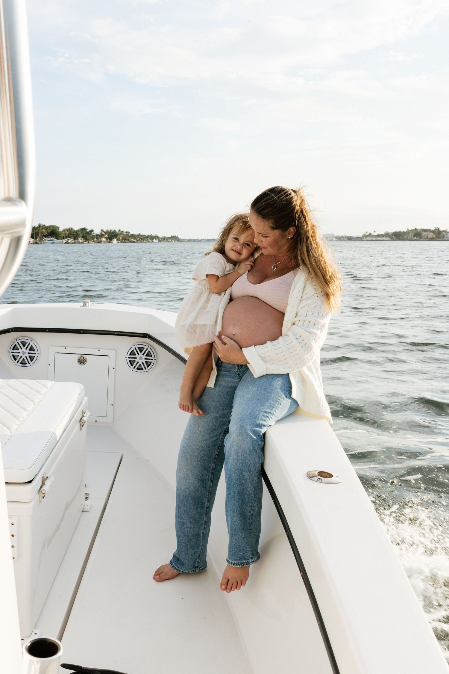 A family embraces while enjoying a boat ride on sunny waters.